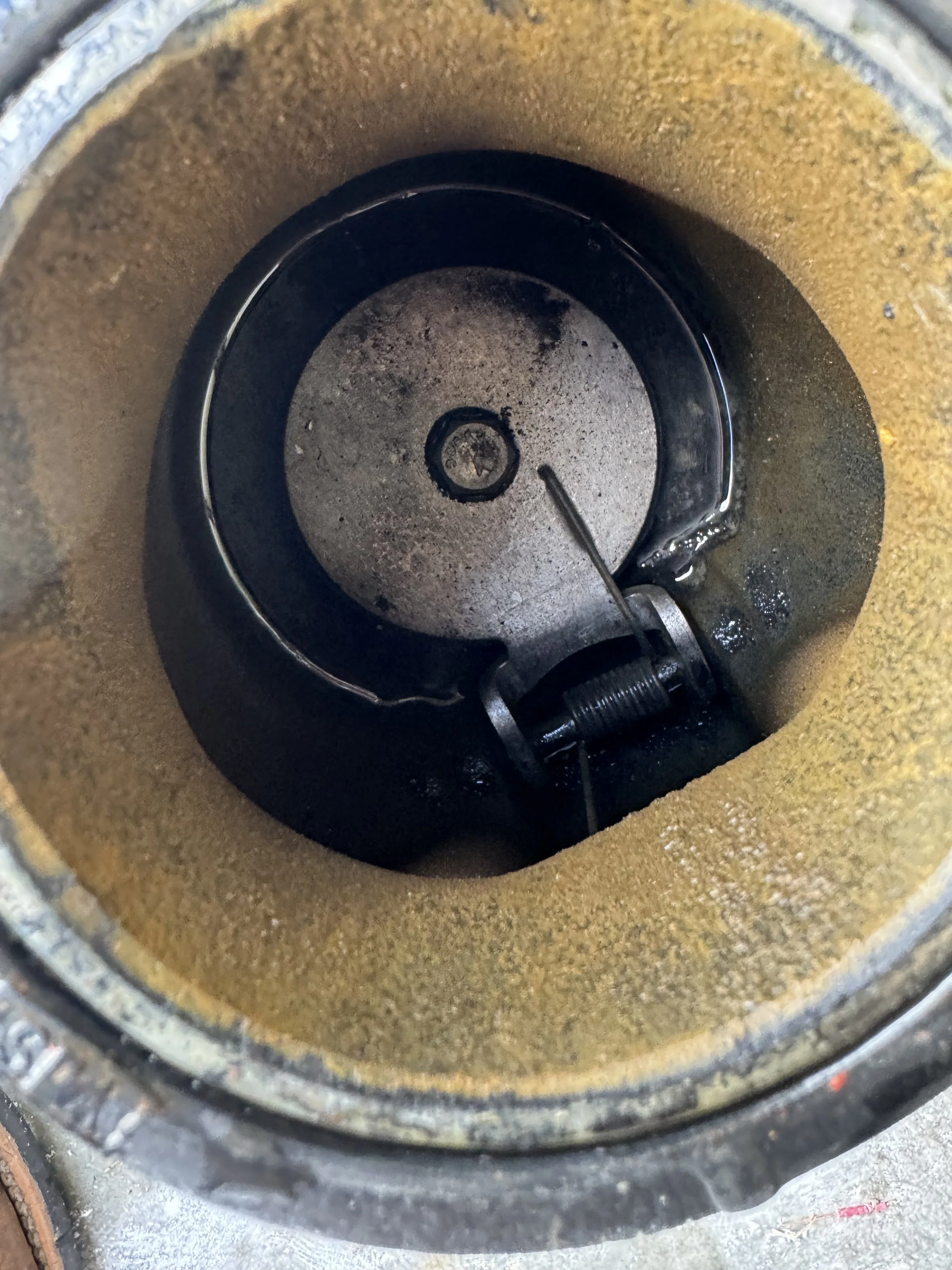 Inside view of an oil filter housing with a spring and metal components, showing the filter element.