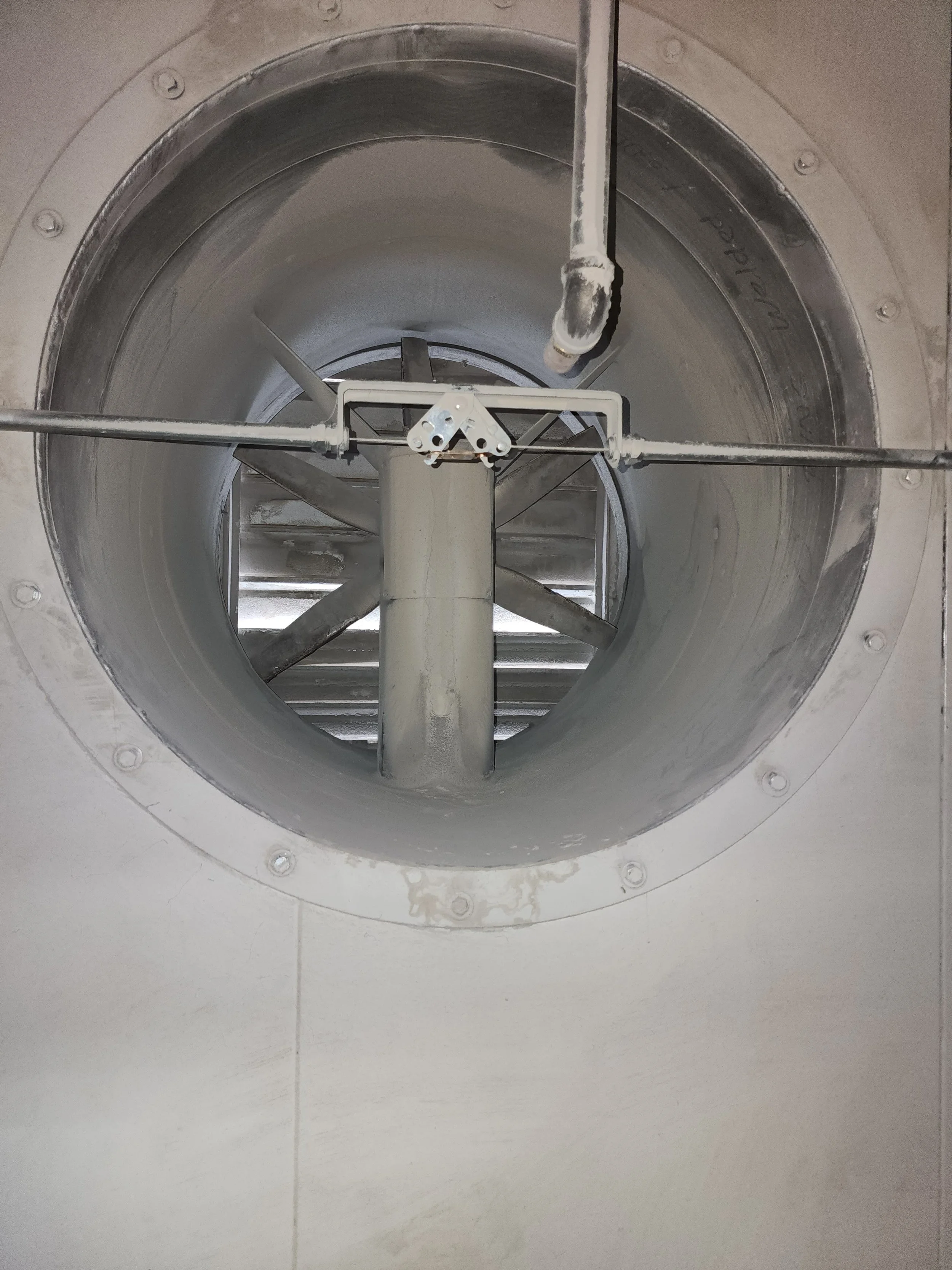 Looking into a large industrial or mechanical pipe with a metal support structure inside.