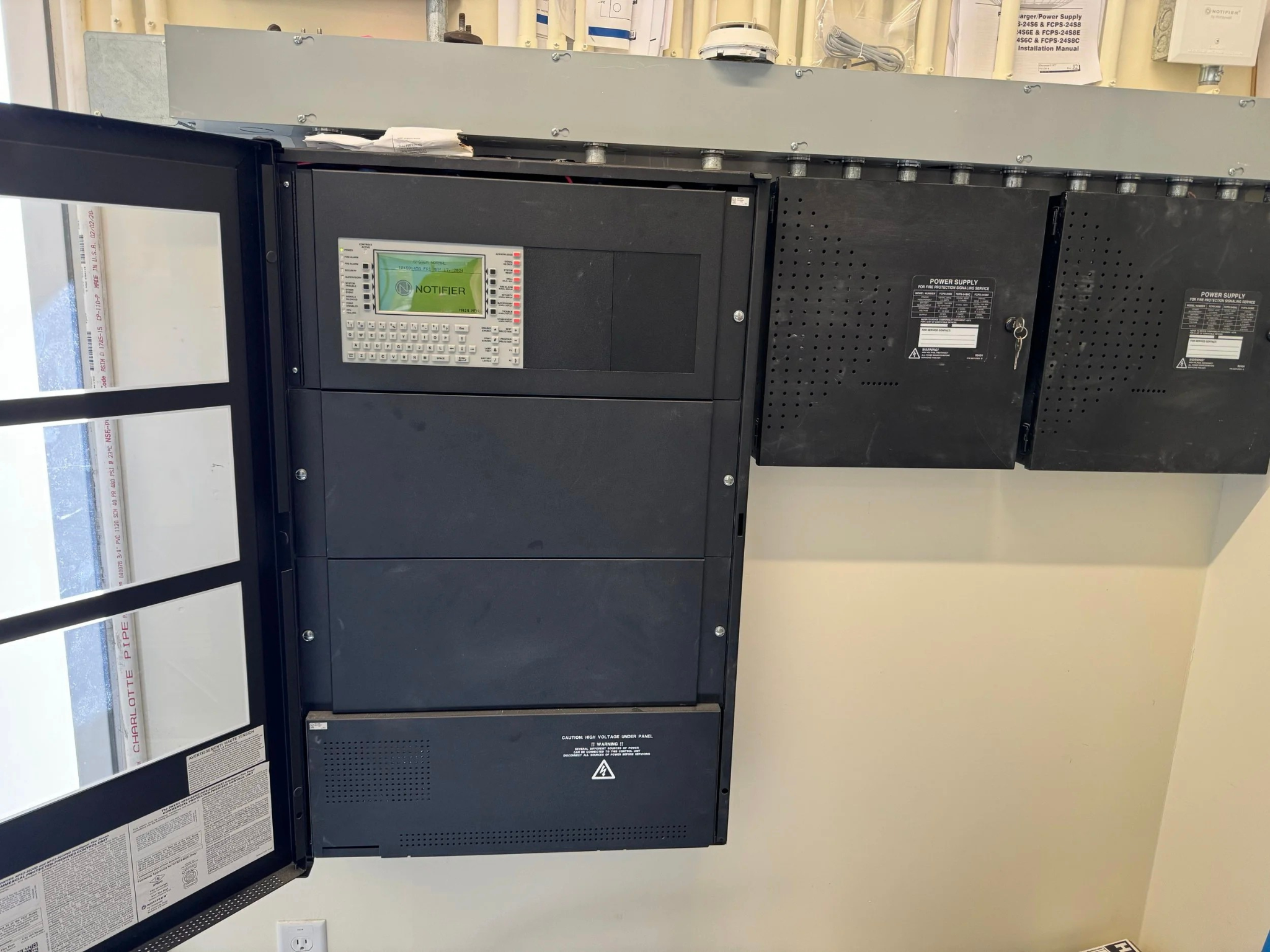 Electrical equipment and panels mounted on a wall inside a building.