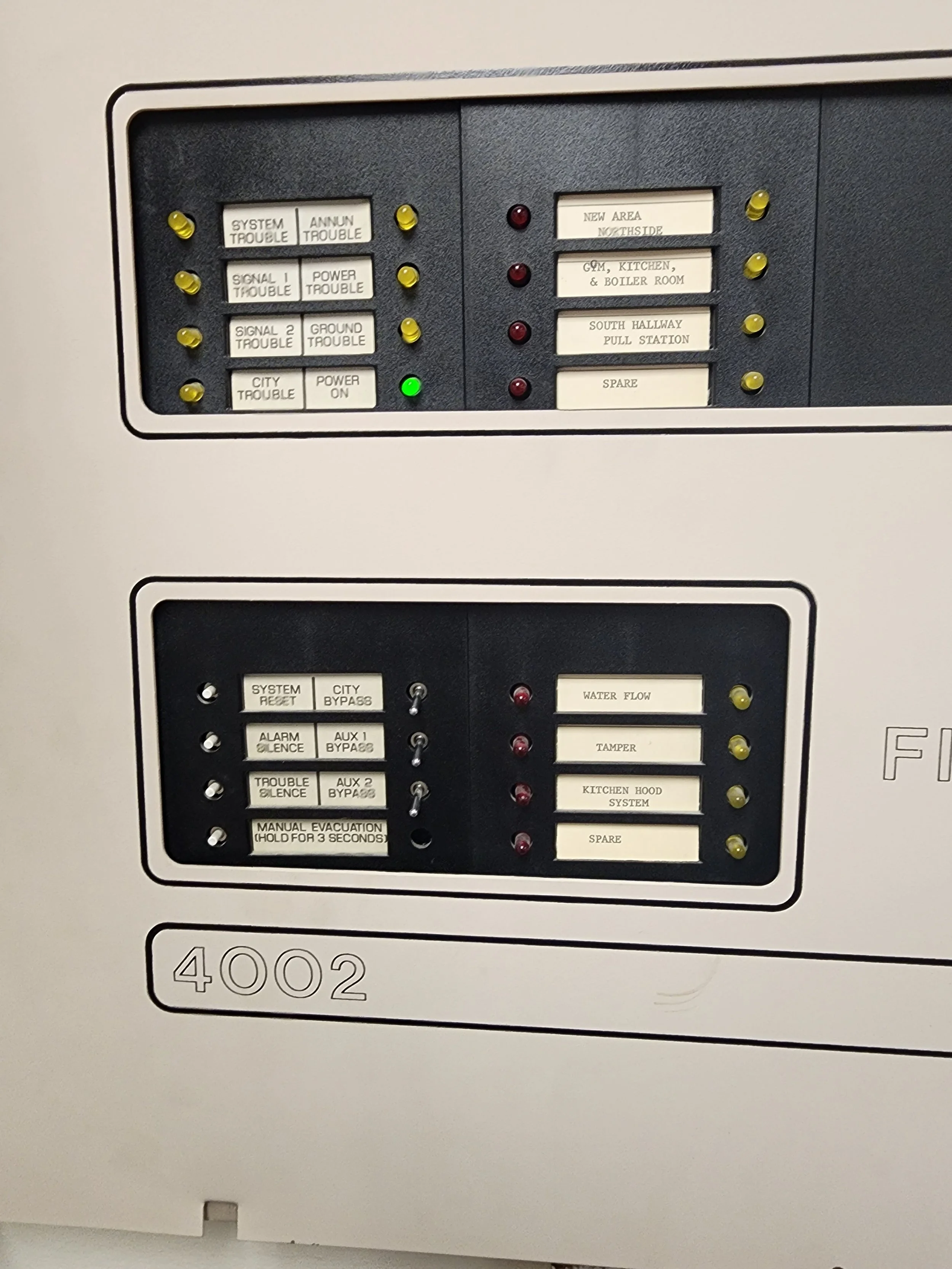 Electrical control panel with indicator lights, labeled switches, and notes related to building or system operations.