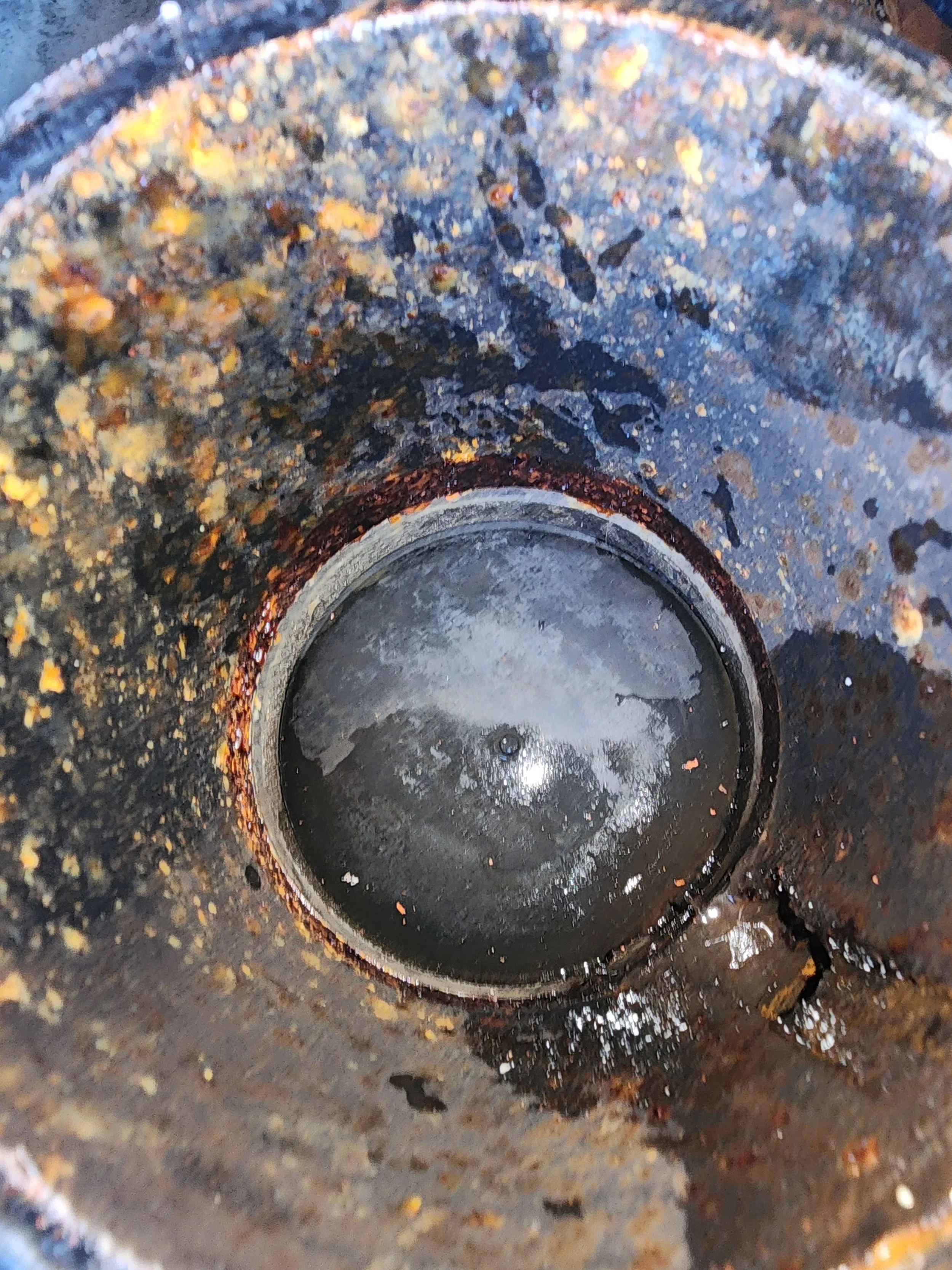 Close-up of a rusty, dirty engine cylinder bore with carbon deposits and oil residue.