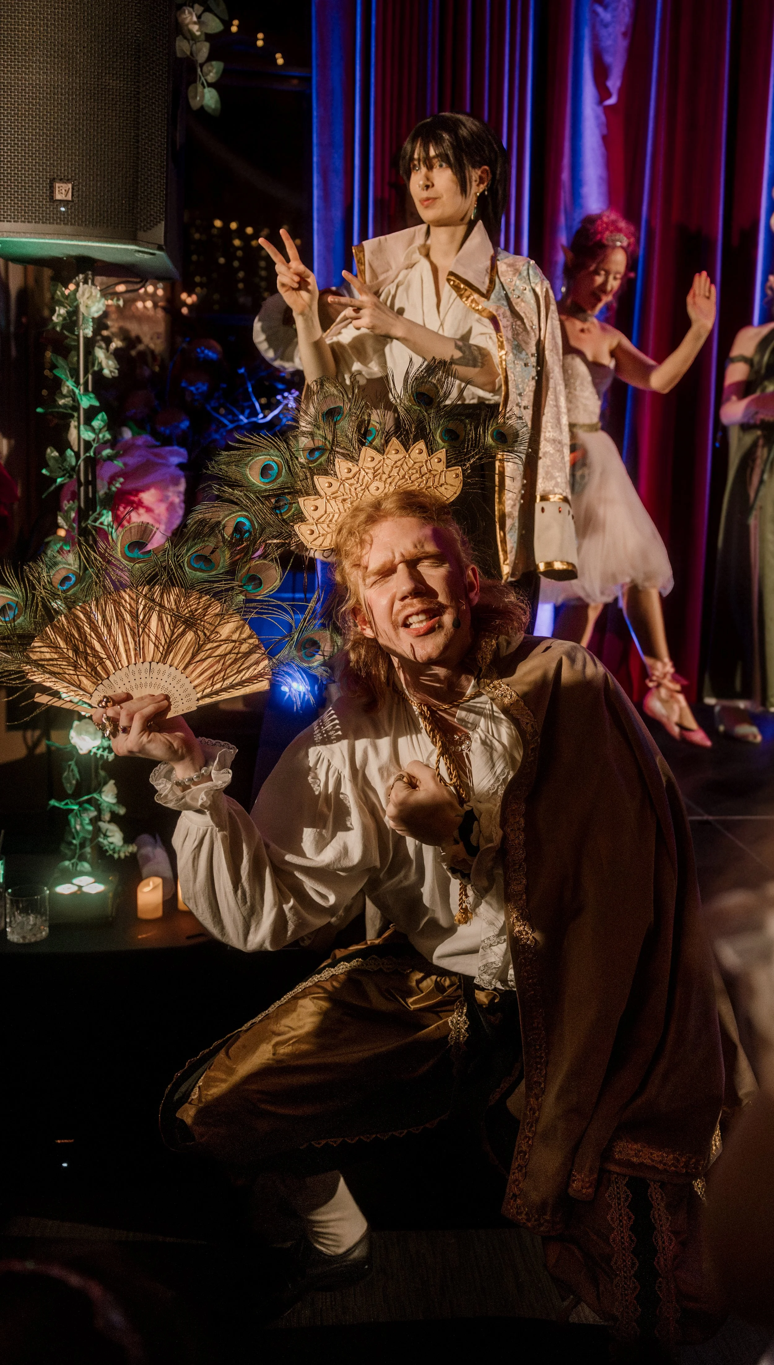A still from a show of Faerieway Events ball, the King Flavius dances and interpretive dance surrounded by his sign language interpreter and others of his court. 