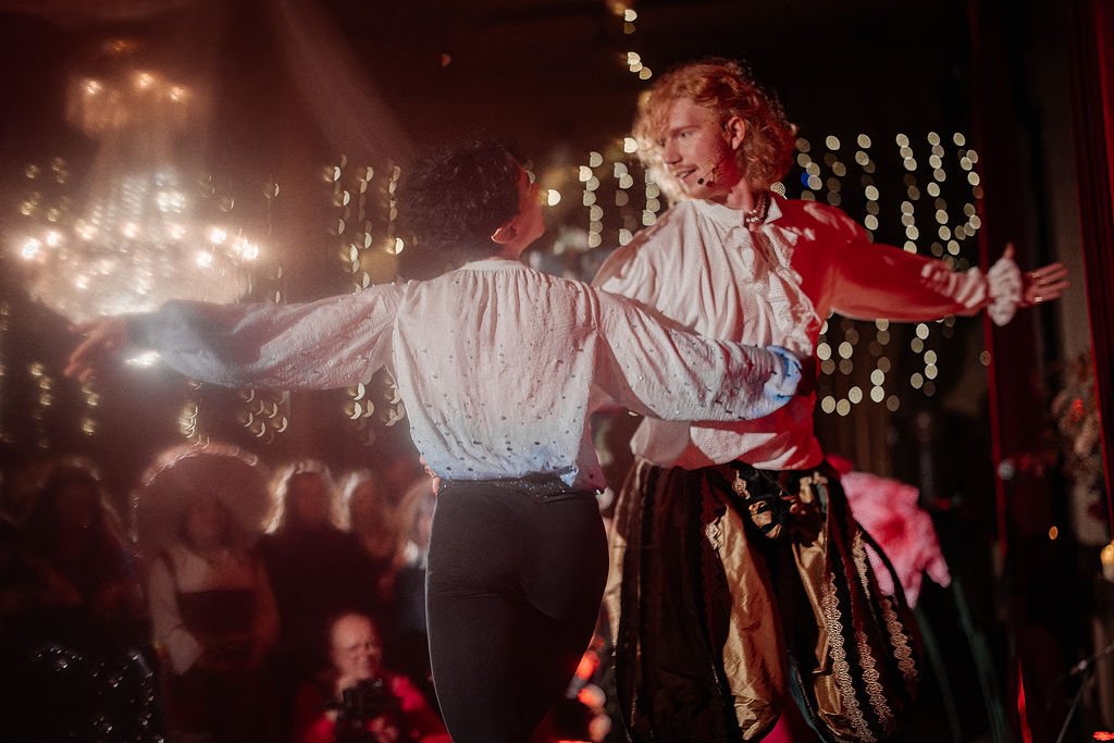 Two dancers twirling on the stage, looking at each other with love