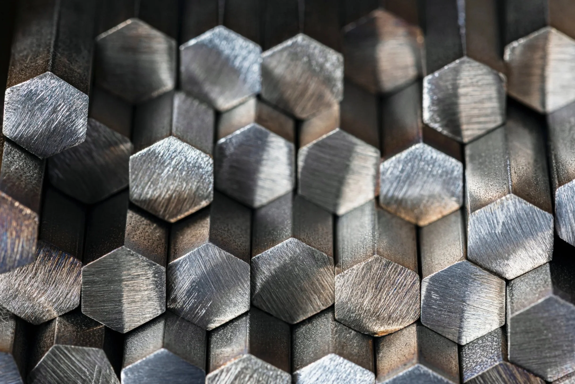 A close-up view of stacked metal rods with hexagonal cross-sections.