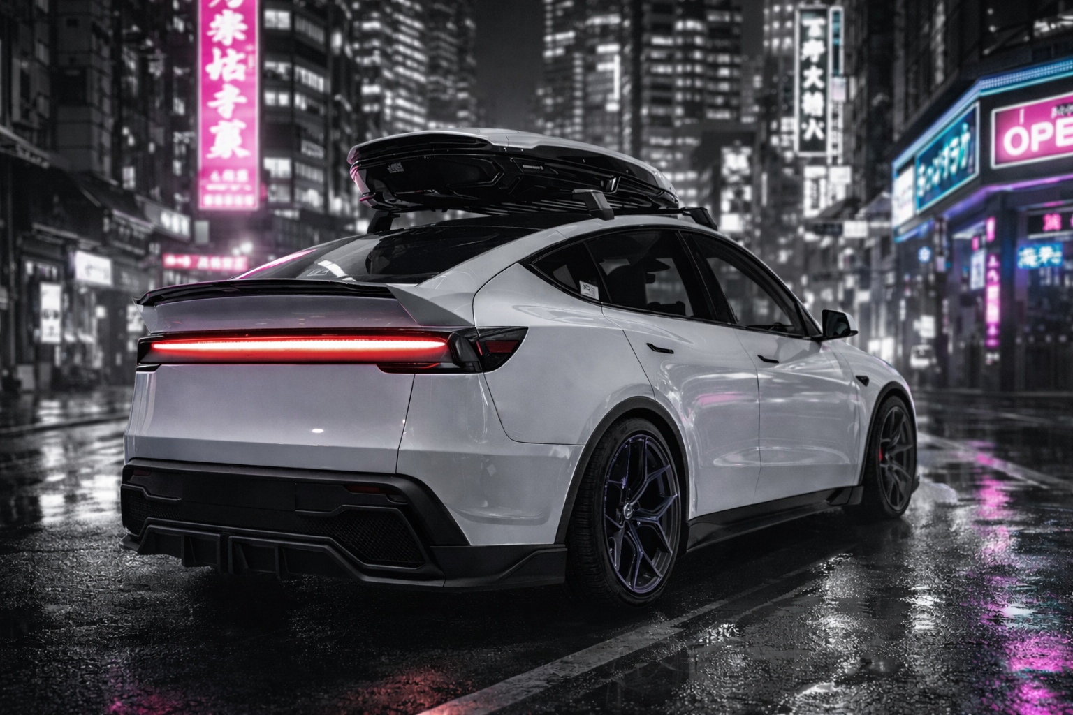 A sleek silver electric car with a rooftop cargo box parked on a wet city street at night, illuminated by neon lights and signs.