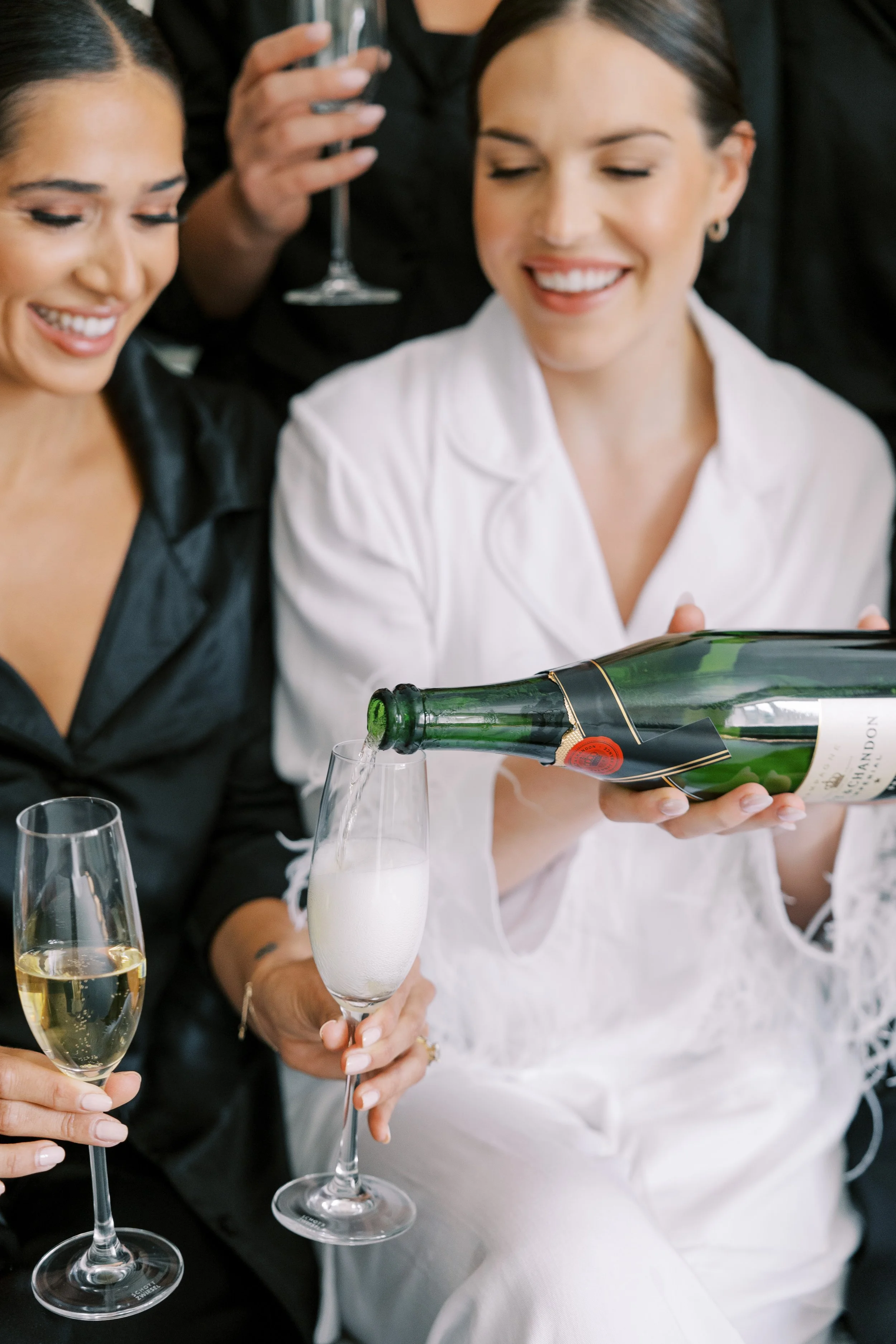 Women pouring and enjoying champagne at a celebration or gathering.