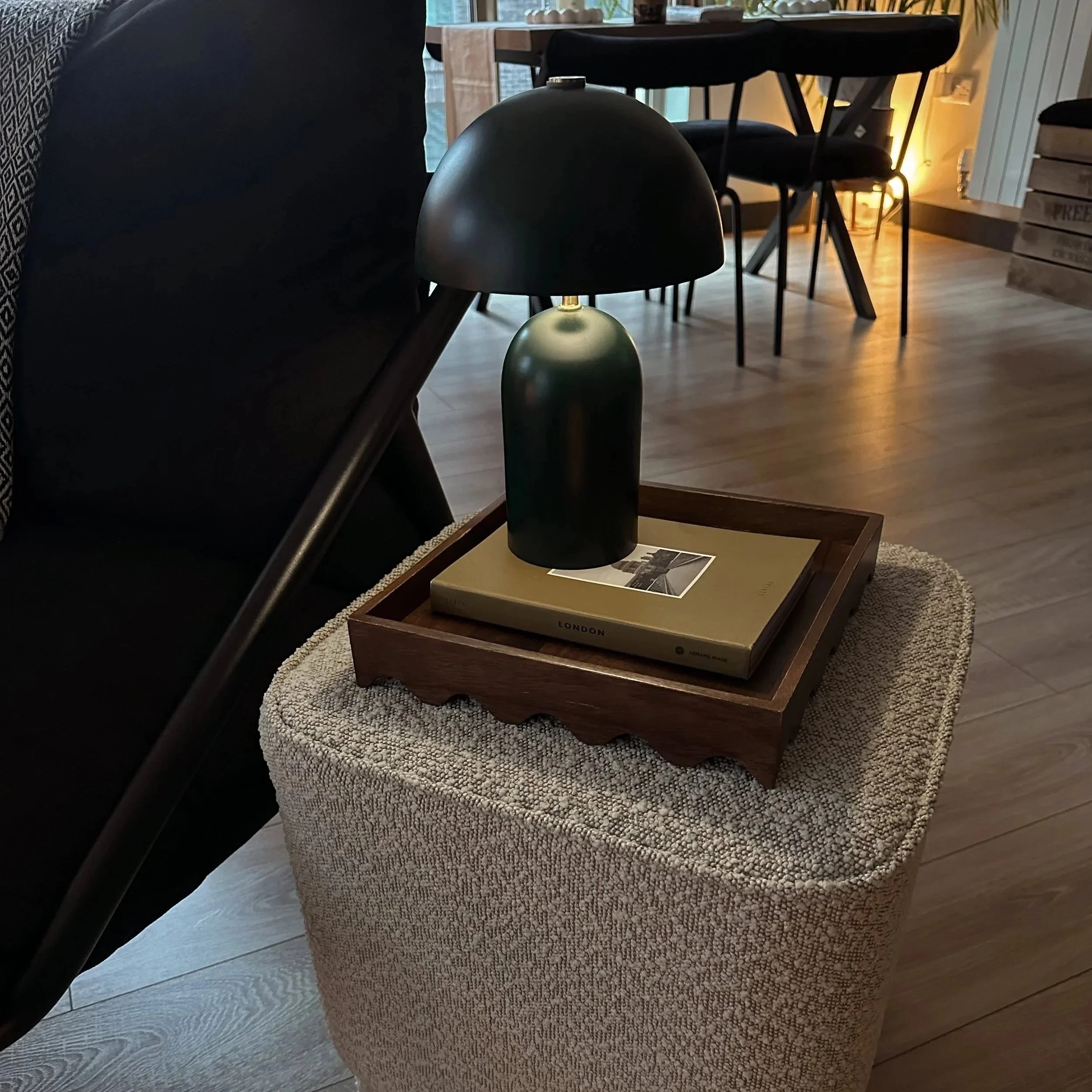 A dark green rechargeable lamp styled on a stool