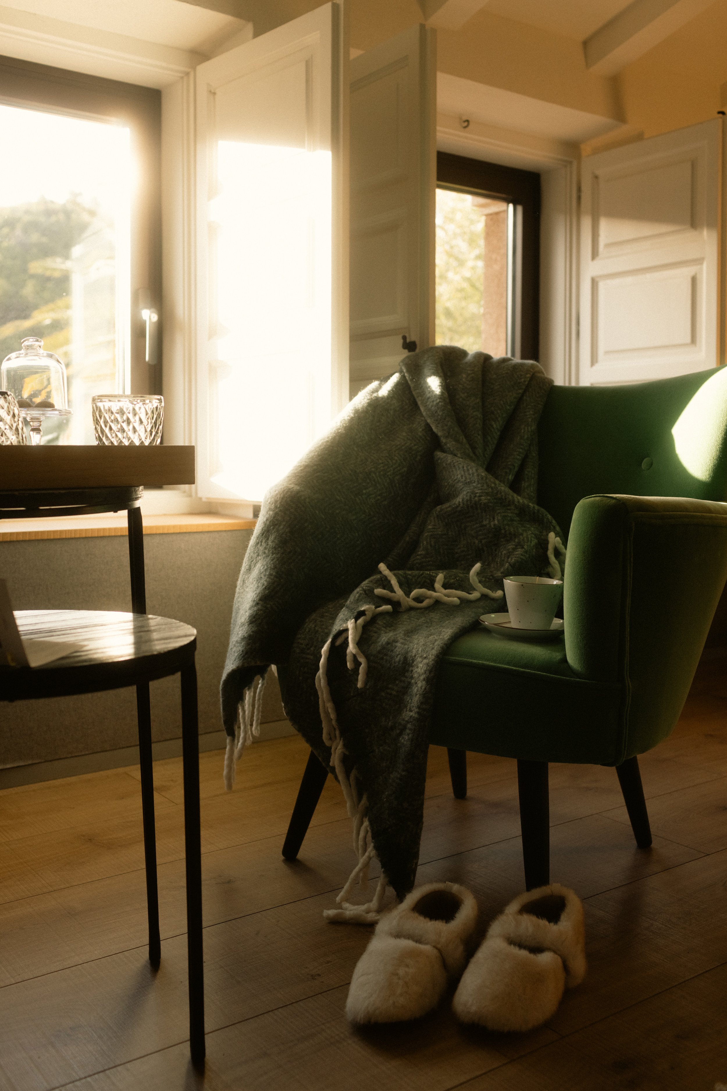 Quiet luxury at Terra Dominicata: a sun-drenched suite corner featuring a velvet armchair and bespoke guest amenities in the Priorat hills.