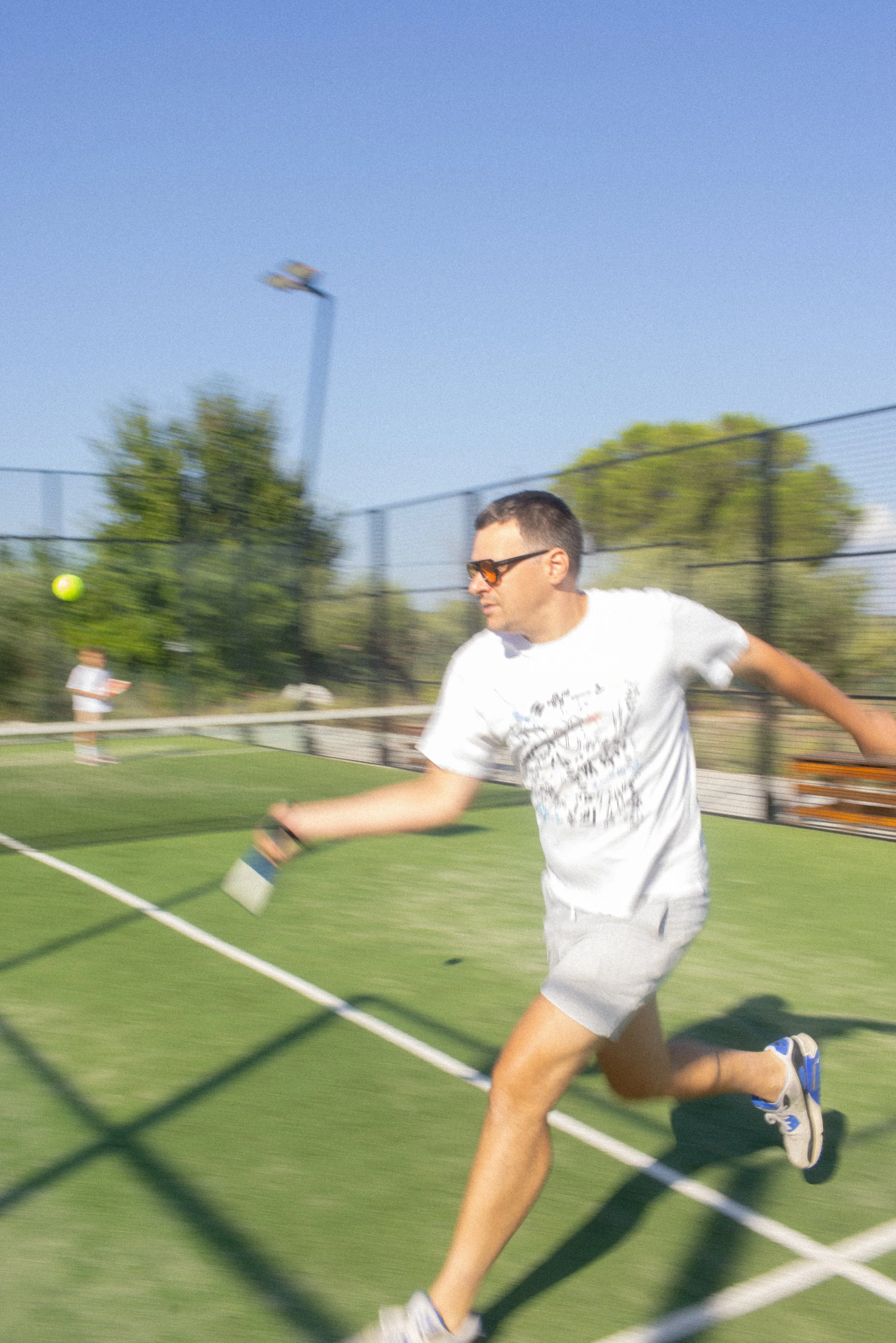 Active guest lifestyle at Font de la Canya: playing tennis on the outdoor court under a clear Mediterranean sky.