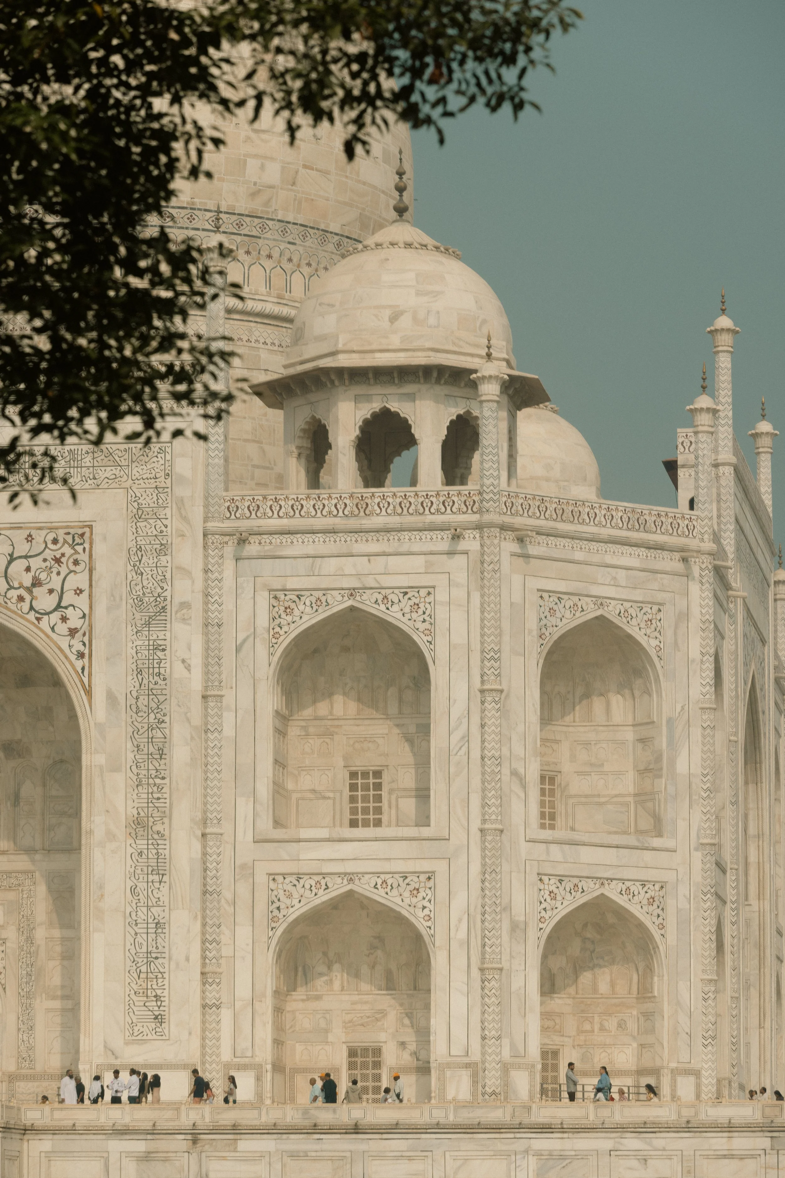 Architectural heritage photography: A detailed close-up of the Taj Mahal’s marble facade with intricate carvings and arched windows. Professional travel portfolio shot for Deccan Odyssey.