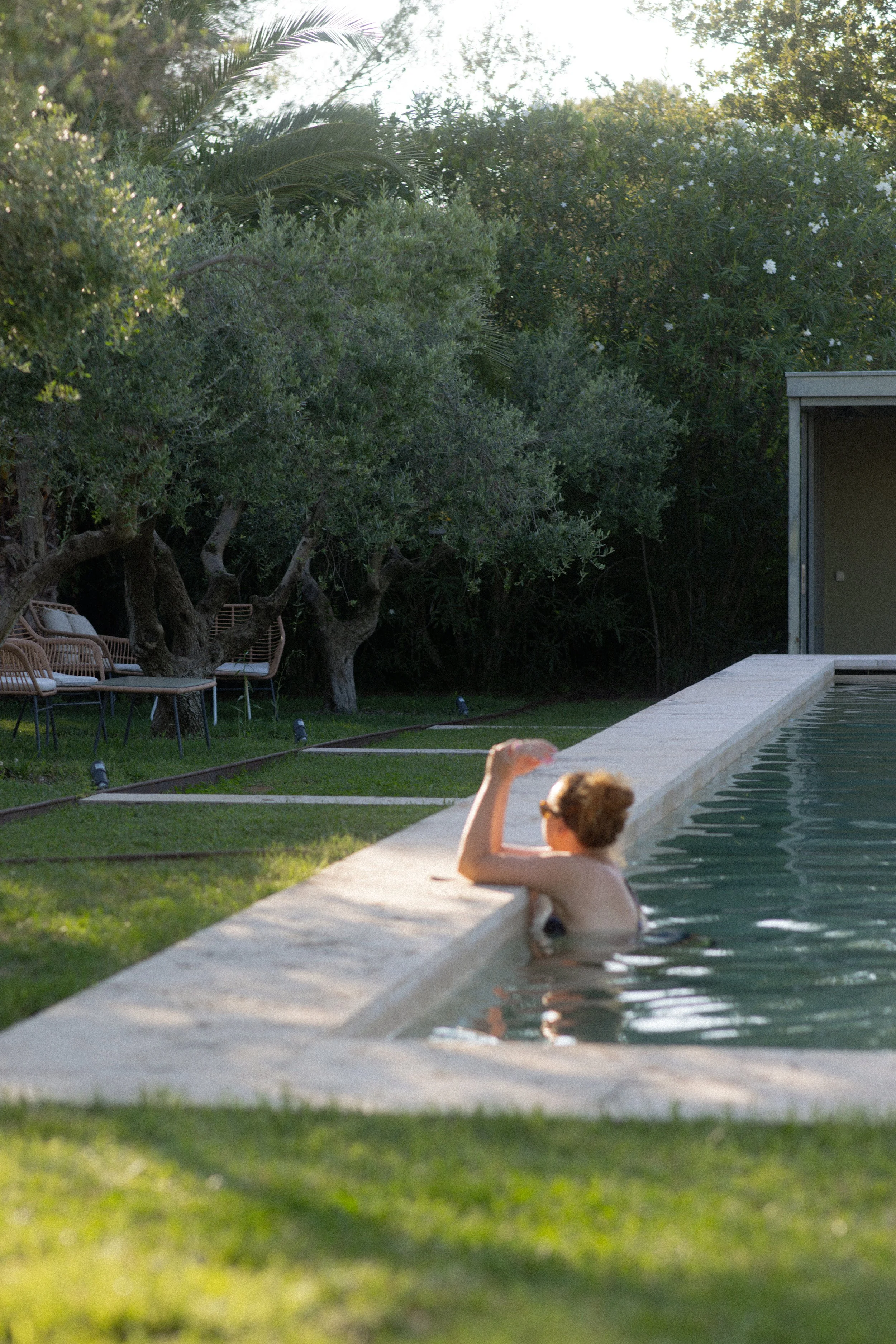 Luxury pool lifestyle at Font de la Canya: relaxing guest experience surrounded by lush Mediterranean greenery.