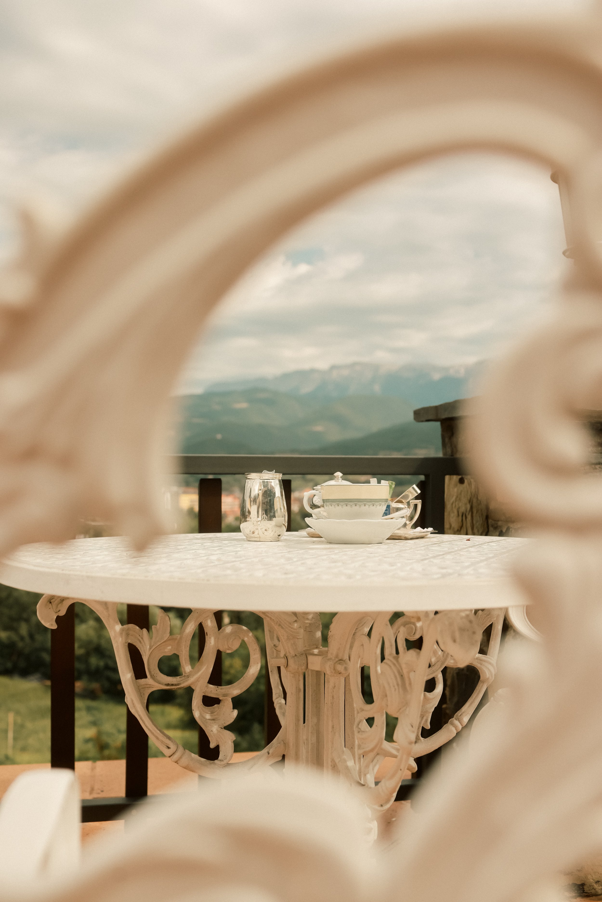 Luxury tea service at El Castell de Ciutat: private balcony with panoramic Pyrenees mountain views.
