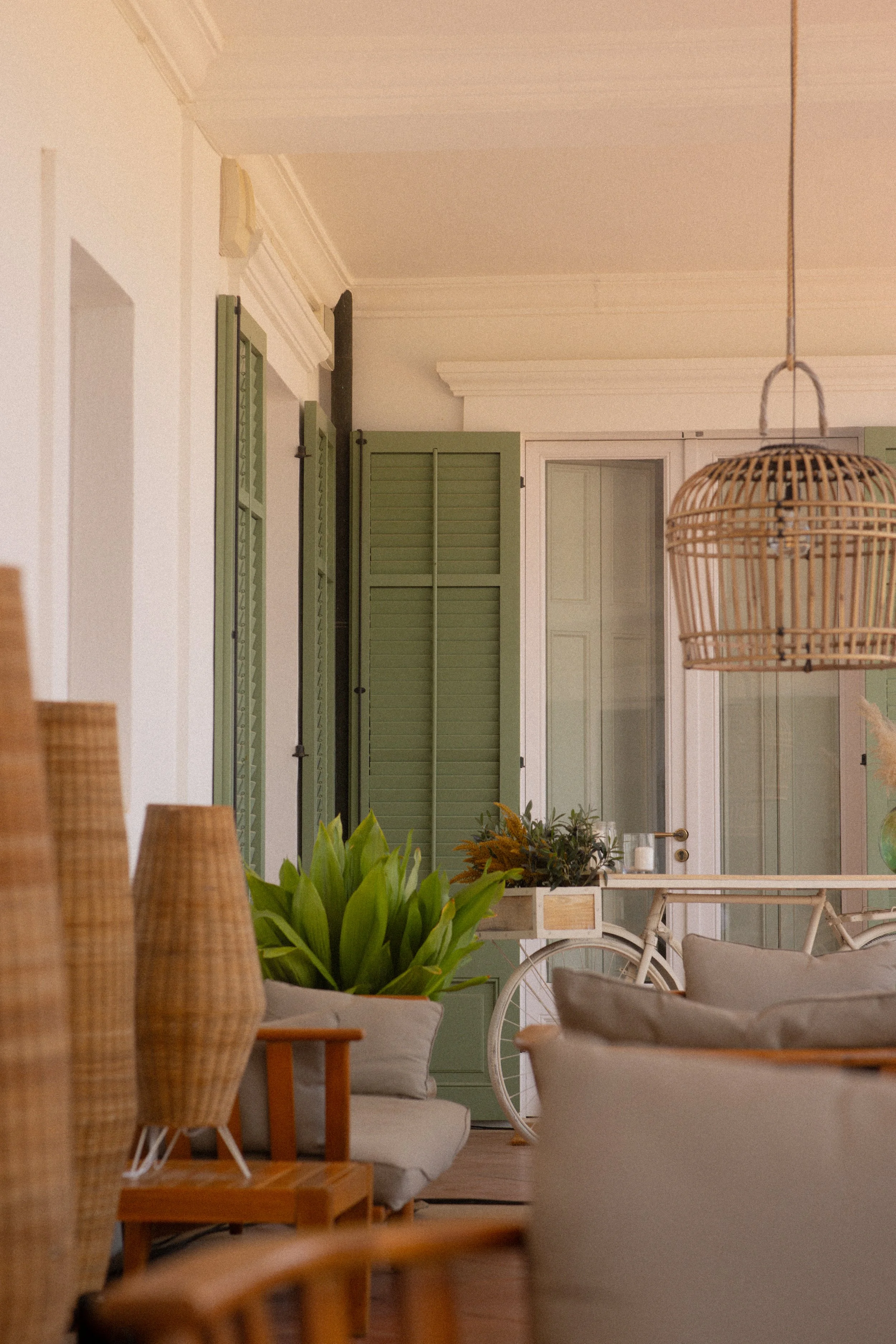 Boutique Mediterranean interior design at Font de la Canya: cozy room with green cabinet, bicycle, and wicker details.