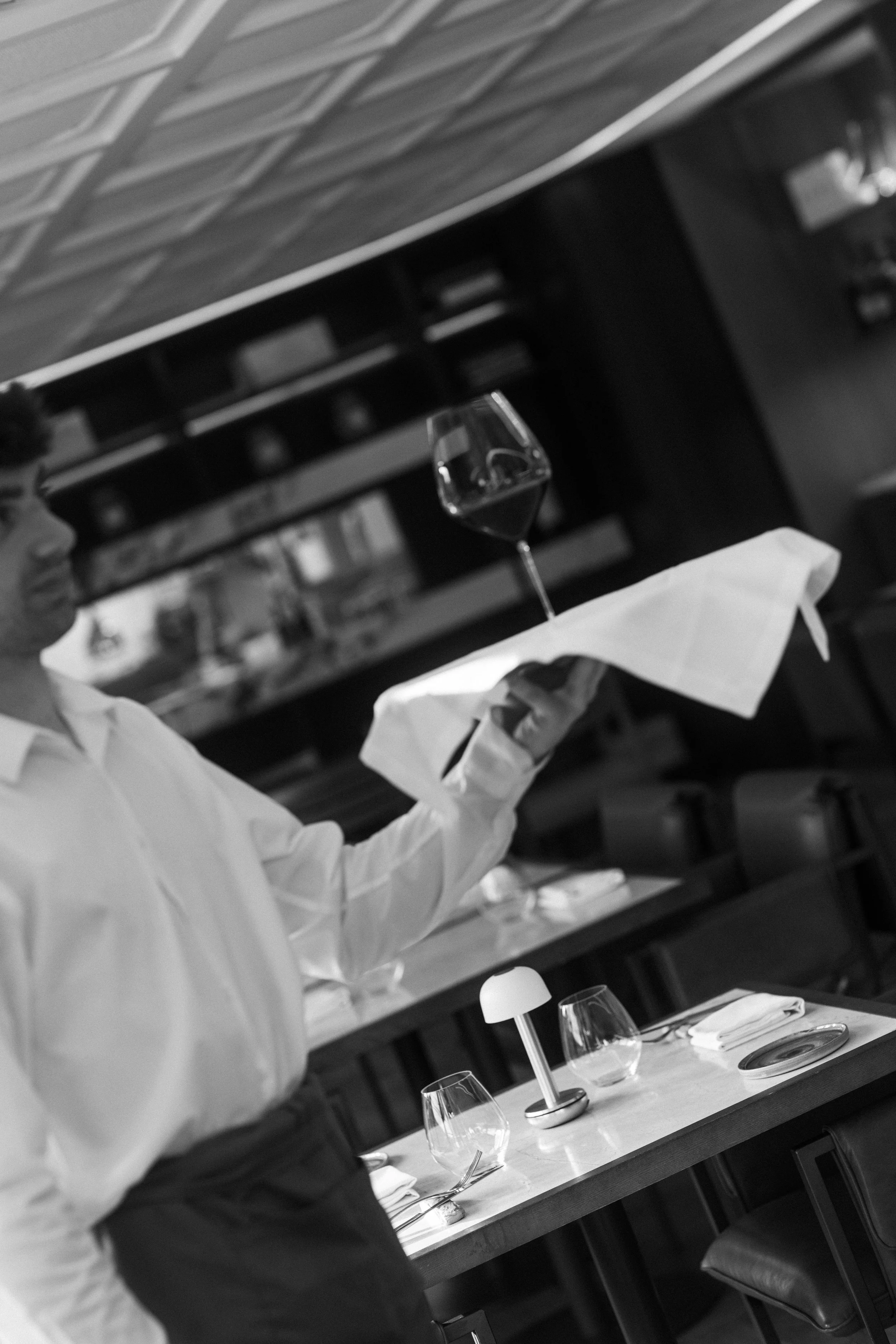 Cinematic elegance at Mas d'en Bruno: a striking black and white portrait of sophisticated wine service in the Priorat estate's premier restaurant.