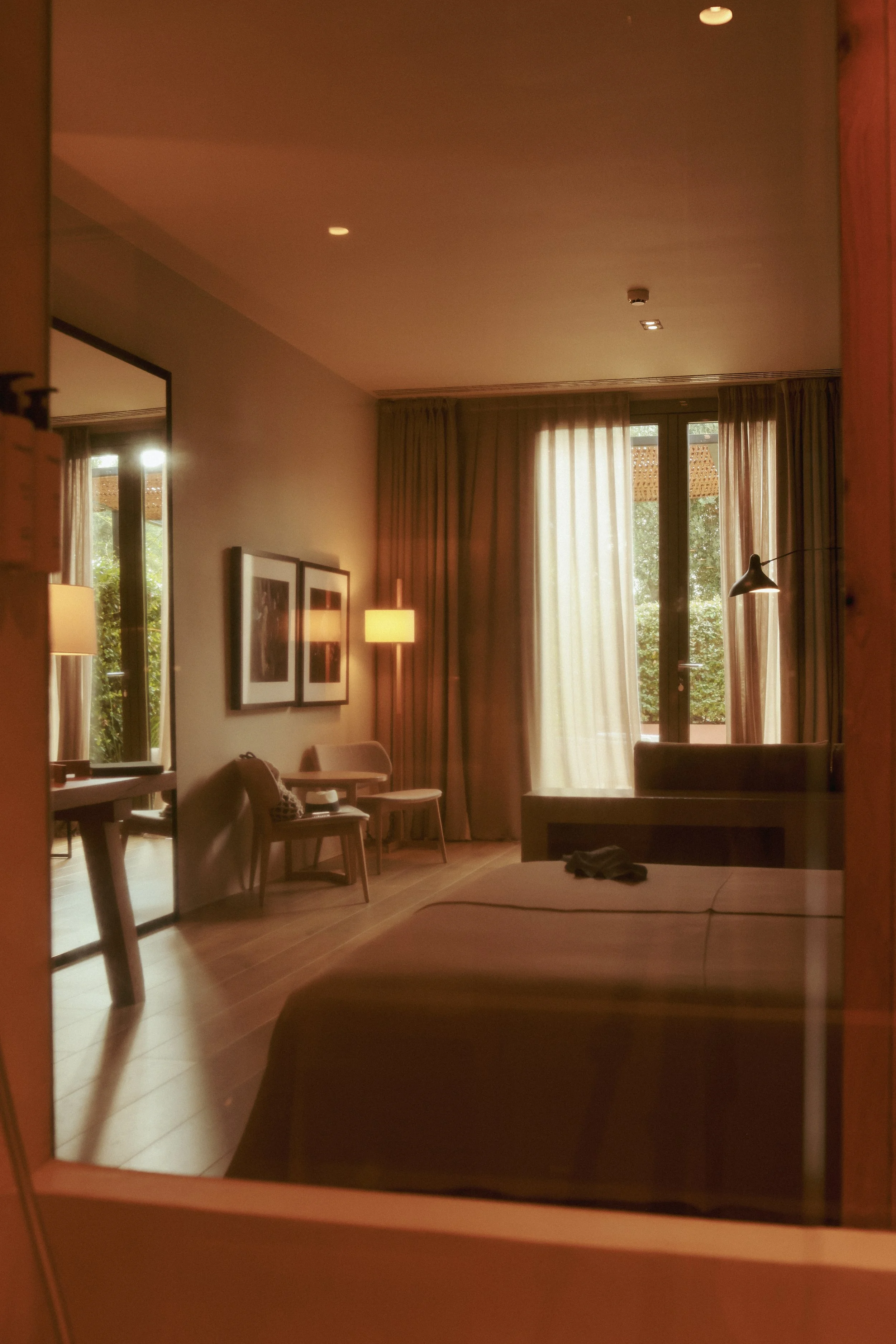 Sophisticated interior design at Hotel Perelada: a mirror reflection showing a luxury suite with artistic wall decor.