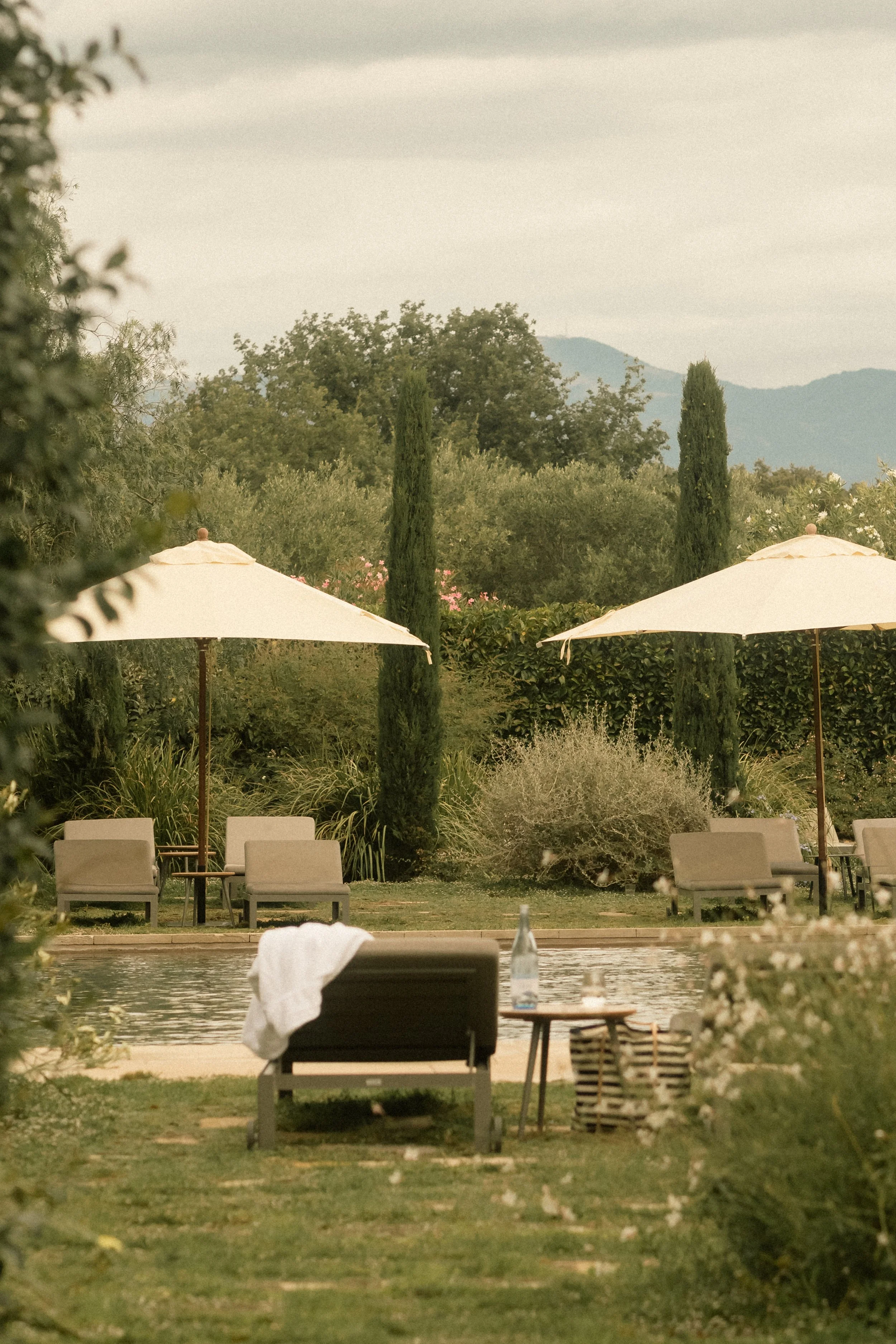 Relaxing poolside vista at Hotel Perelada: lounge area with mountain view under a dramatic sky.