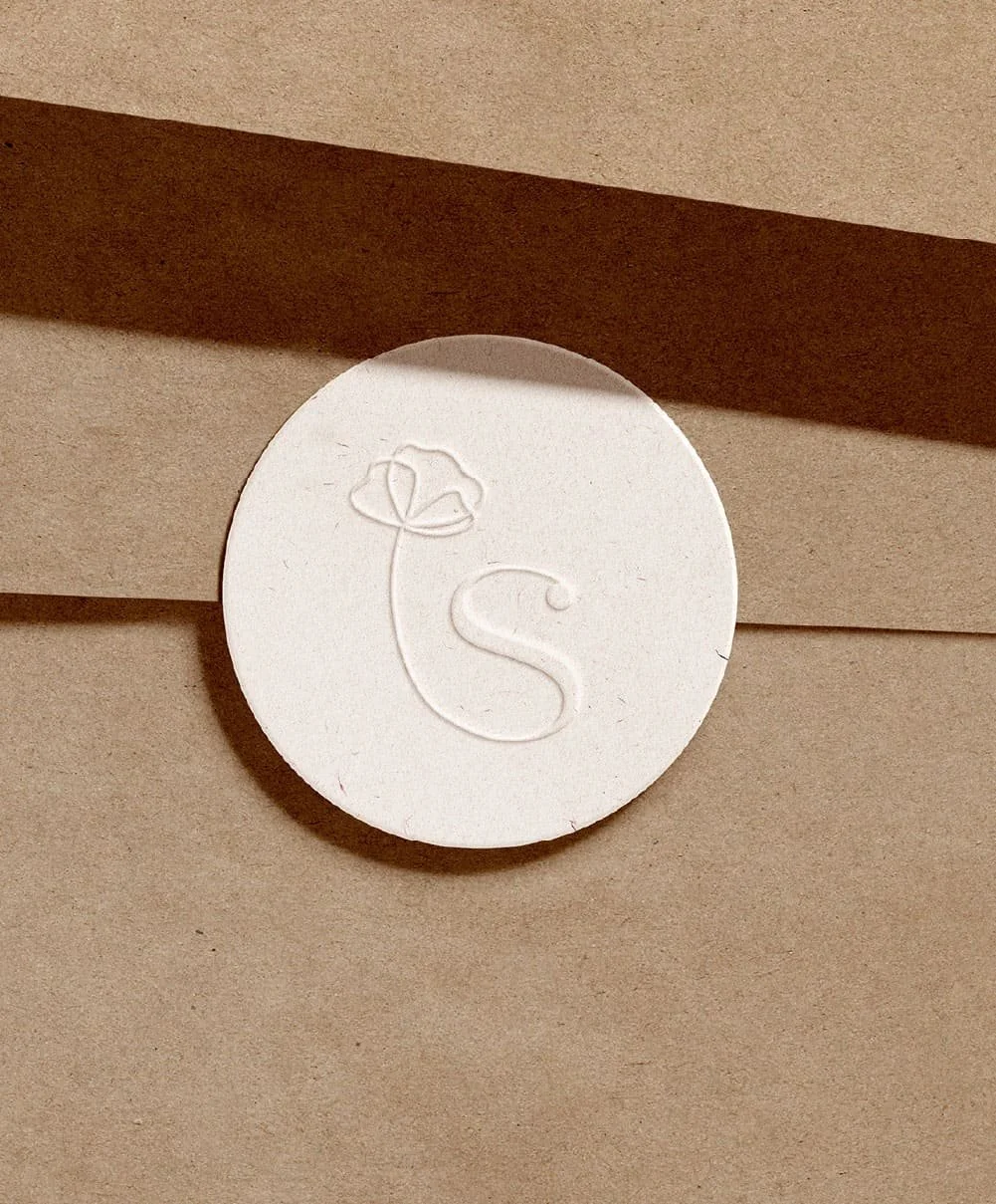 Logo monogramme de la marque de cosmétique naturels Sizens, mis en scène sur une enveloppe en papier kraft.