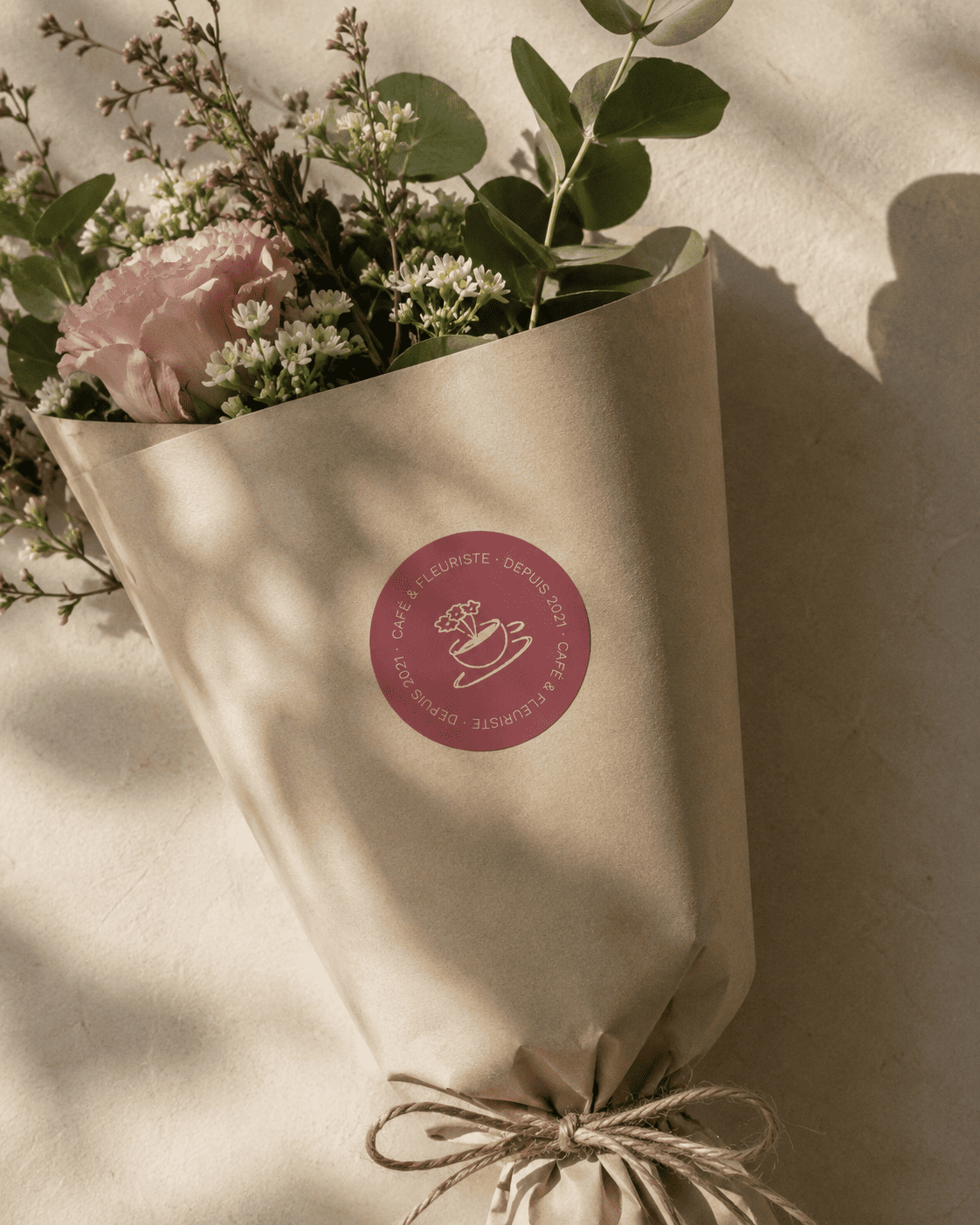 Mise en situation d'un sticker pour Folia, collé sur le papier kraft d'un bouquet de fleurs.