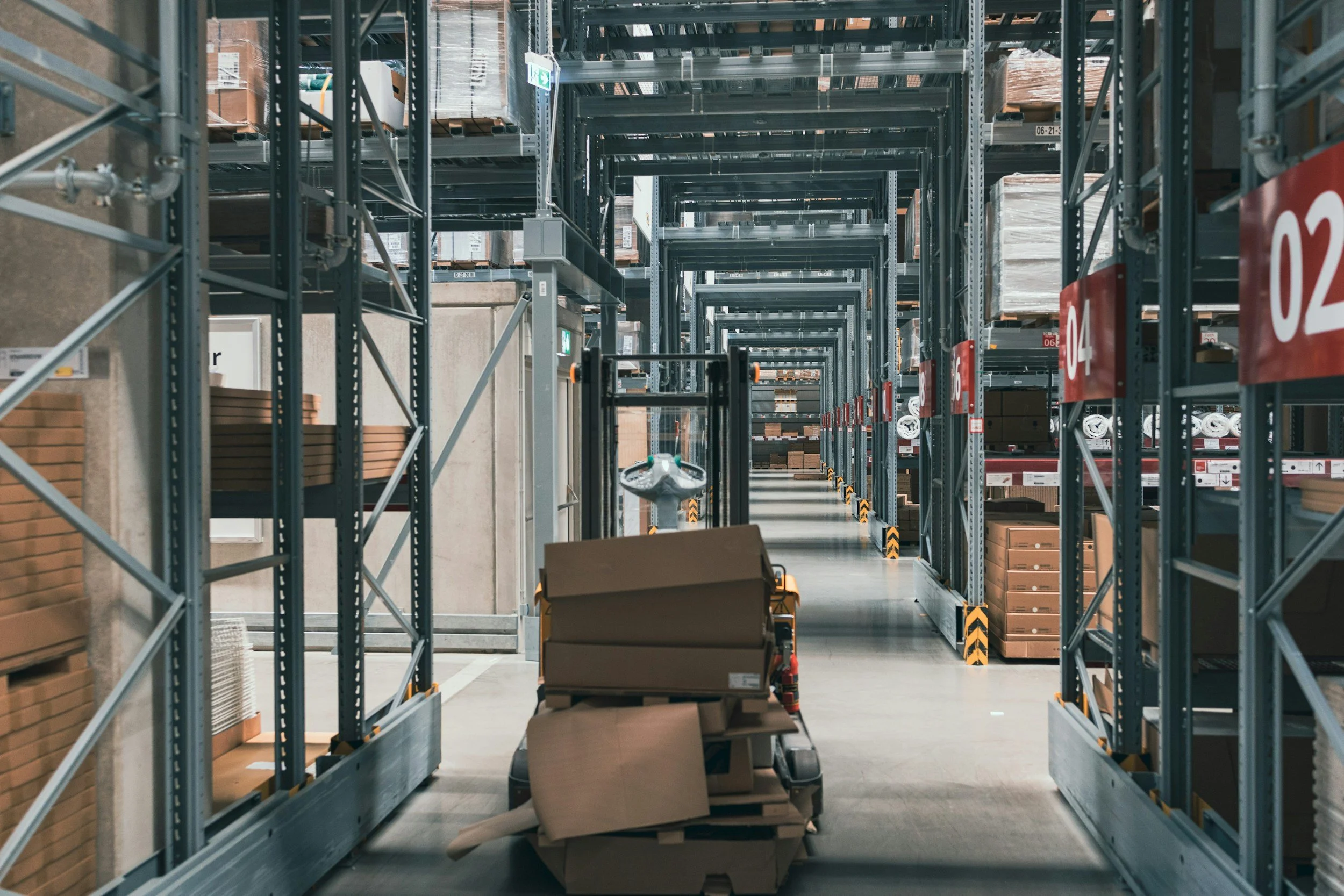 Rayonnages de stockage dans un entrepôt avec des cartons et des palettes, vue en profondeur