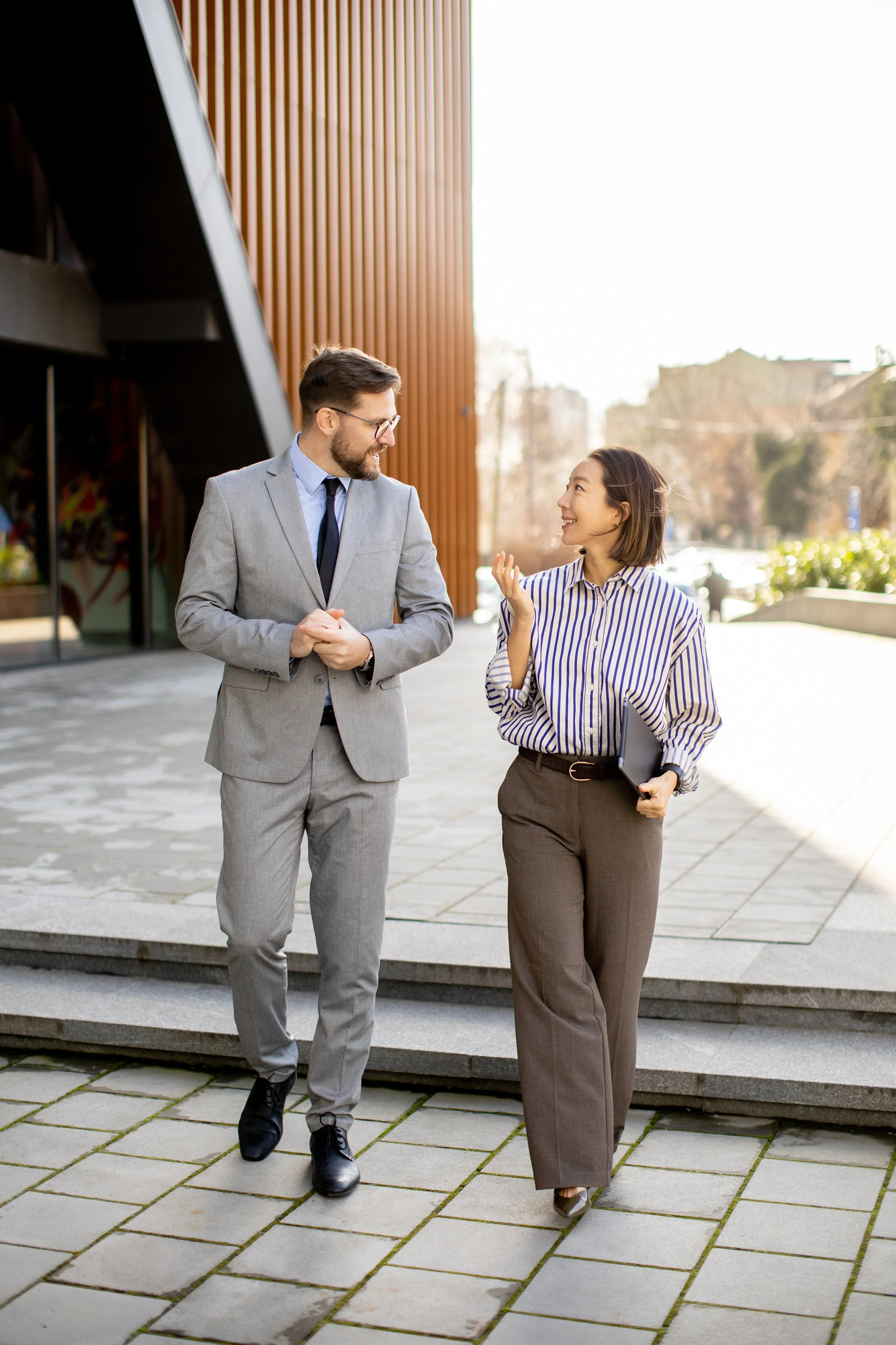 Consultants talking about strategic planning outside a big office building.