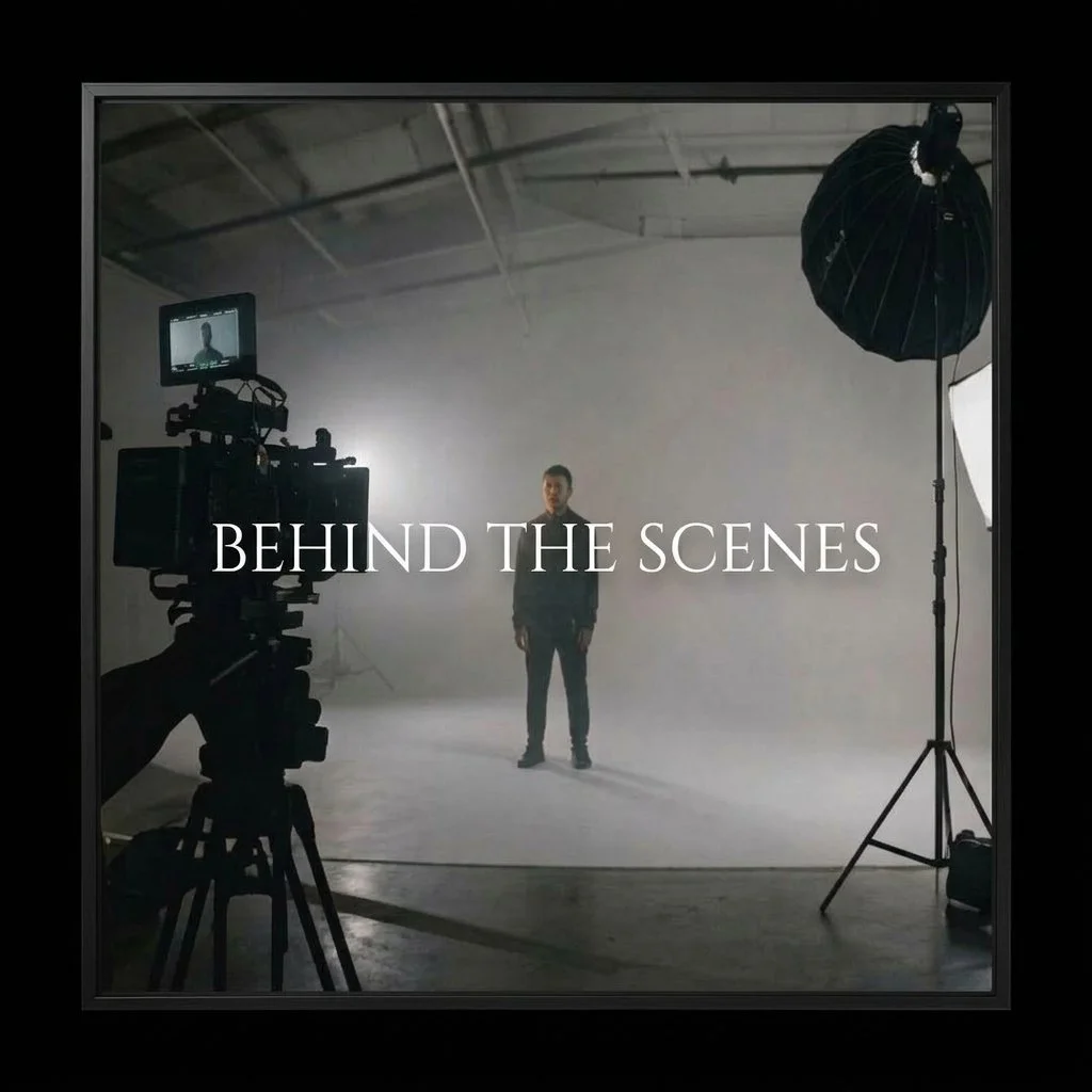 Studio setup with a camera on a tripod and a person standing in the center, with lighting equipment nearby, and the text "BEHIND THE SCENES" overlaid.