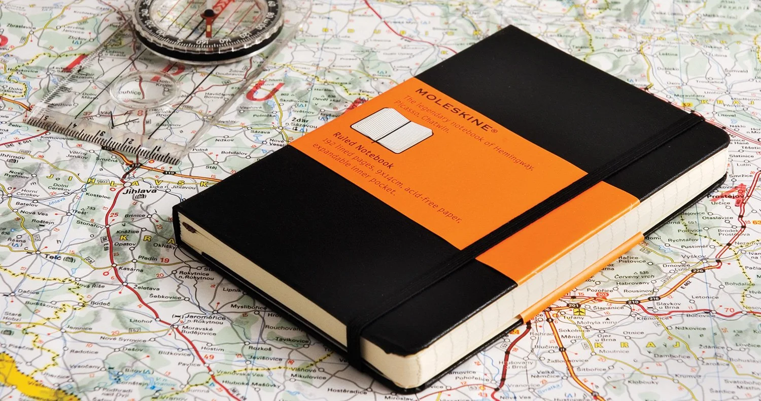 moleskine notebook on a map