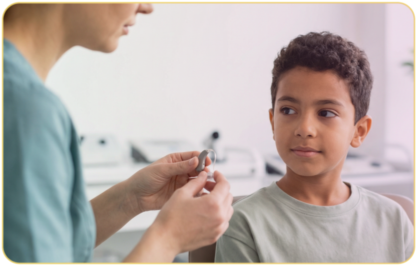 A young boy sitting outdoors at a table while a healthcare professional prepares to place a medical device on his arm.
