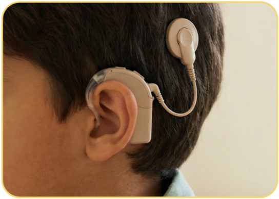 Close-up of a person wearing a behind-the-ear hearing aid with a small earbud and tubing.