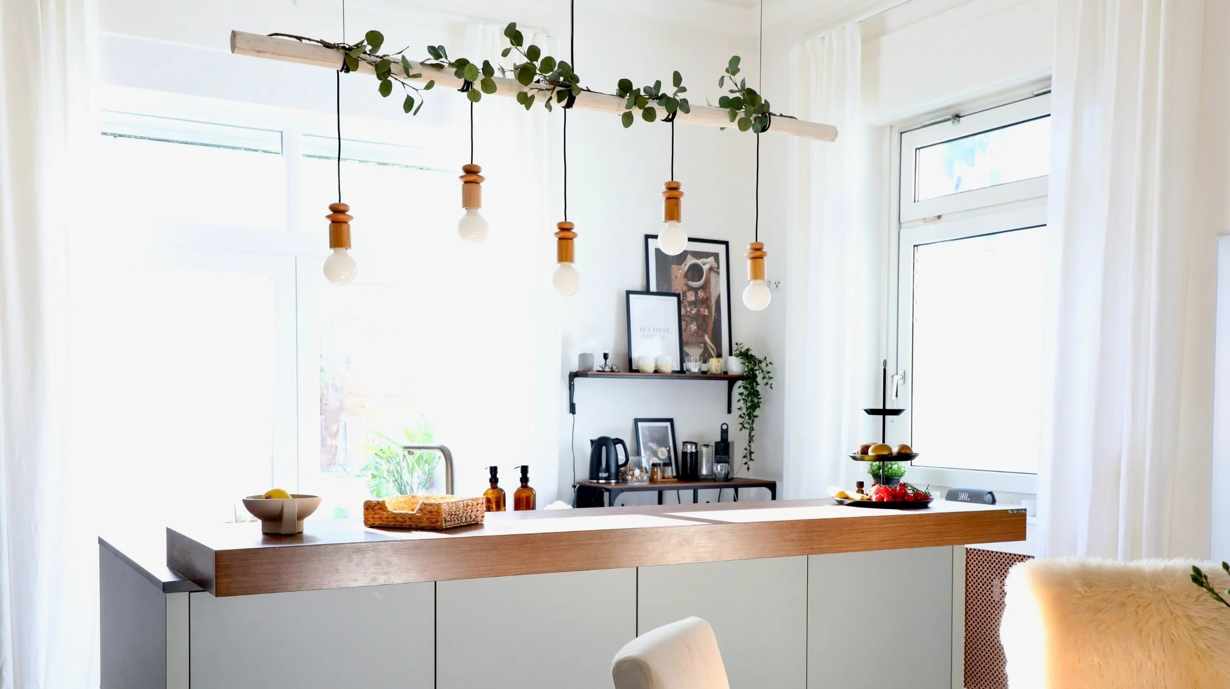 Selbstgebaute Hängelampe aus Holz über der Kücheninsel im Altbau