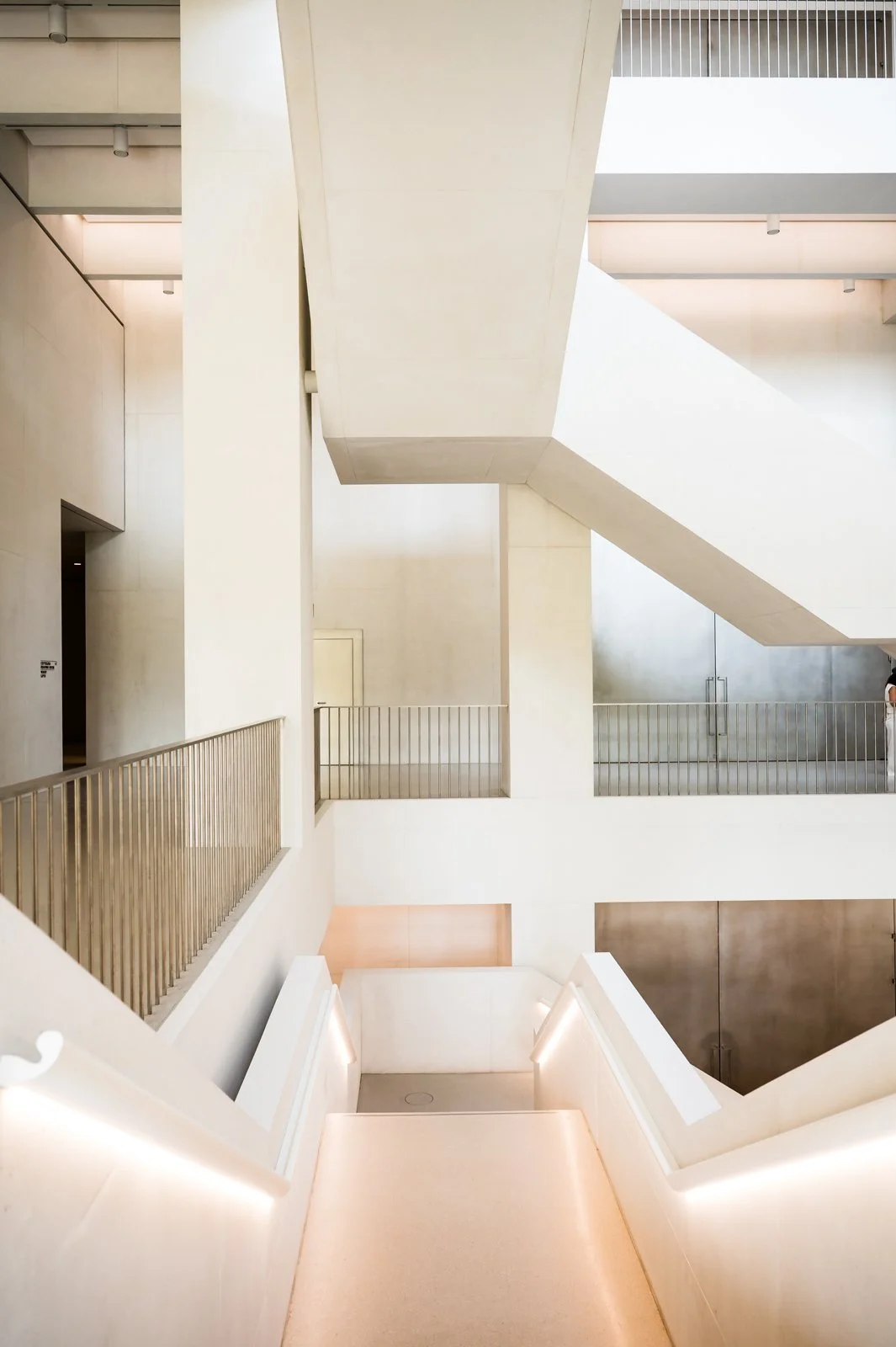 Innenansicht des MSN Museum of Modern Art  in Warschau mit Treppen und Balustraden aus Metall, weißen Wände und heller Beleuchtung.