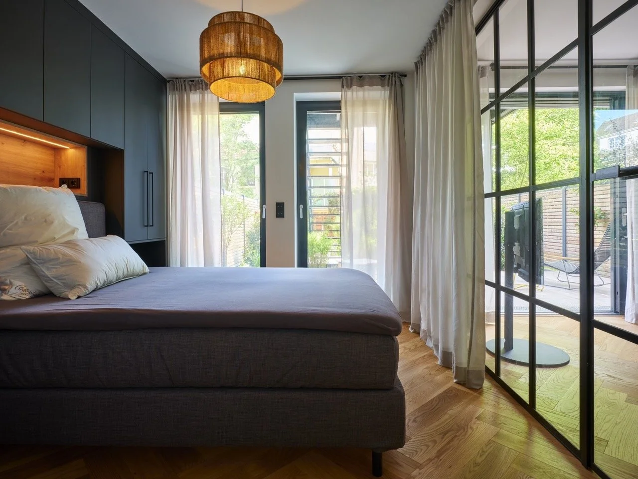 Ruhiges Schlafzimmer mit großen Fenstern und Blick auf Terrasse und Garten im beliebten Wachmannstraßen-Quartier in Bremen.