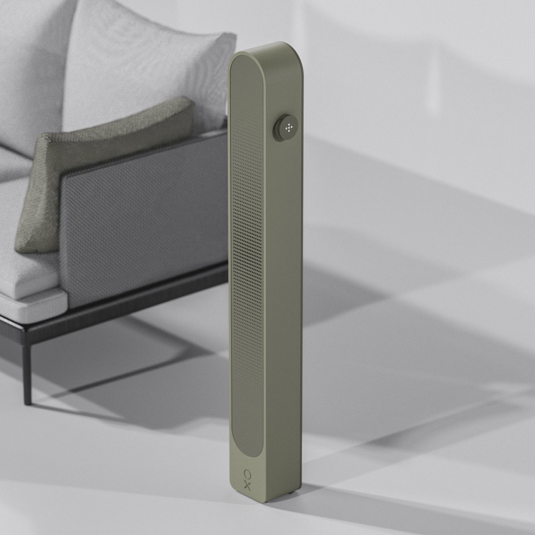 A modern, beige voice-activated speaker standing upright in a minimalistic living room with a sofa and cushions in the background.