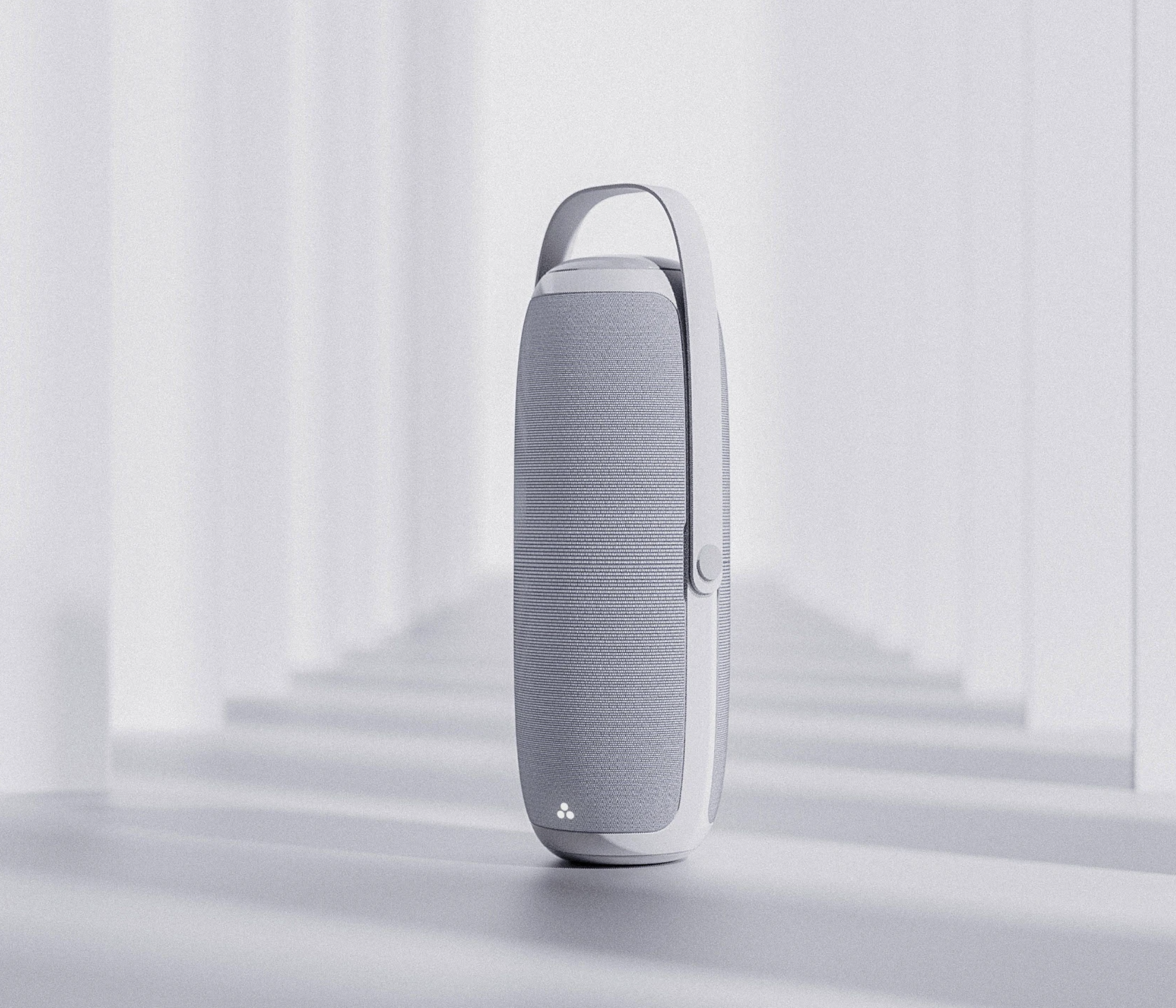 A white and gray portable speaker standing upright on a white surface near a white wall and window.