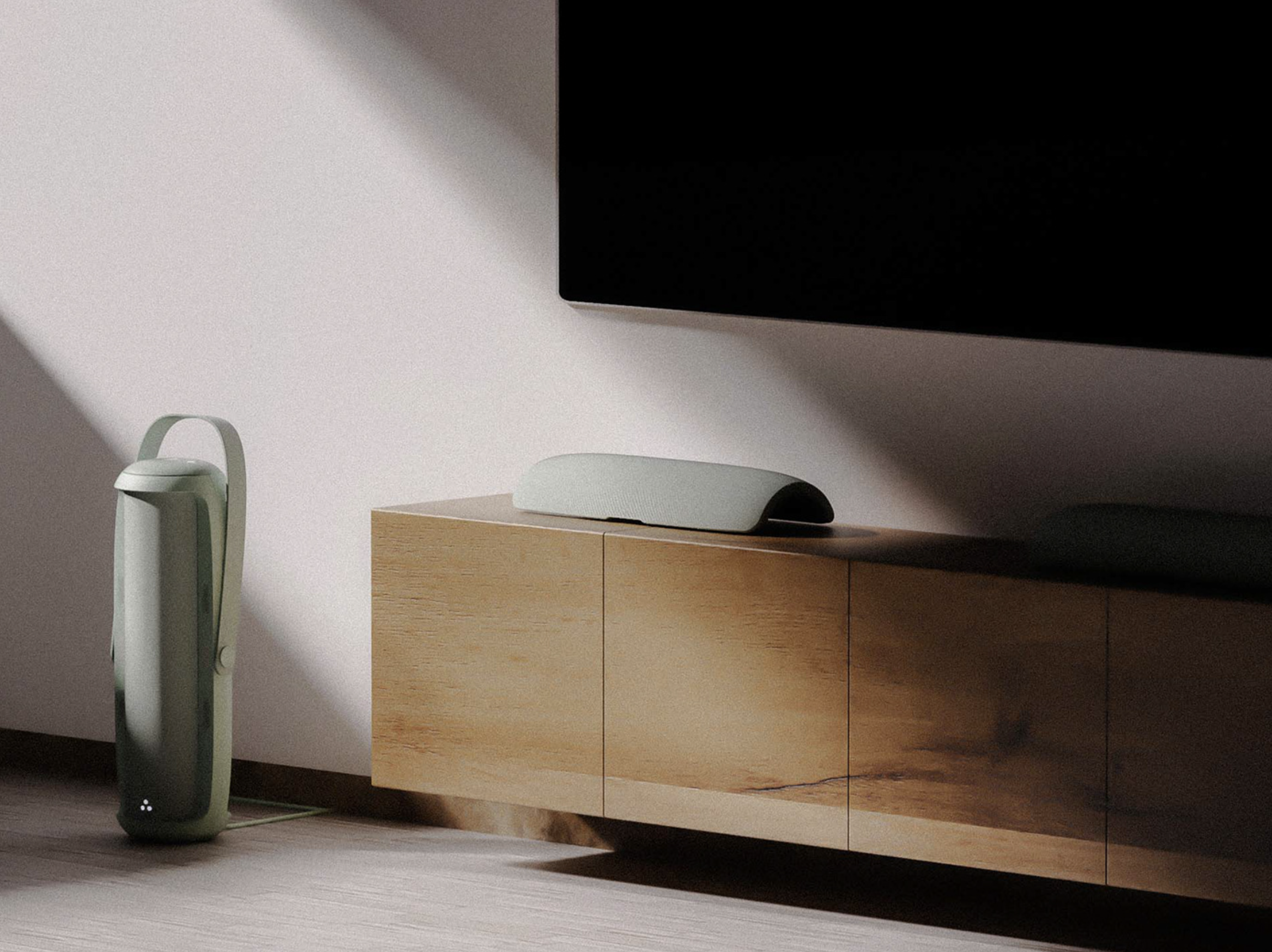 Close-up of a modern wooden TV stand with a lamp on top, a sleek sound bar, and a large flat-screen TV mounted above, with a black background.