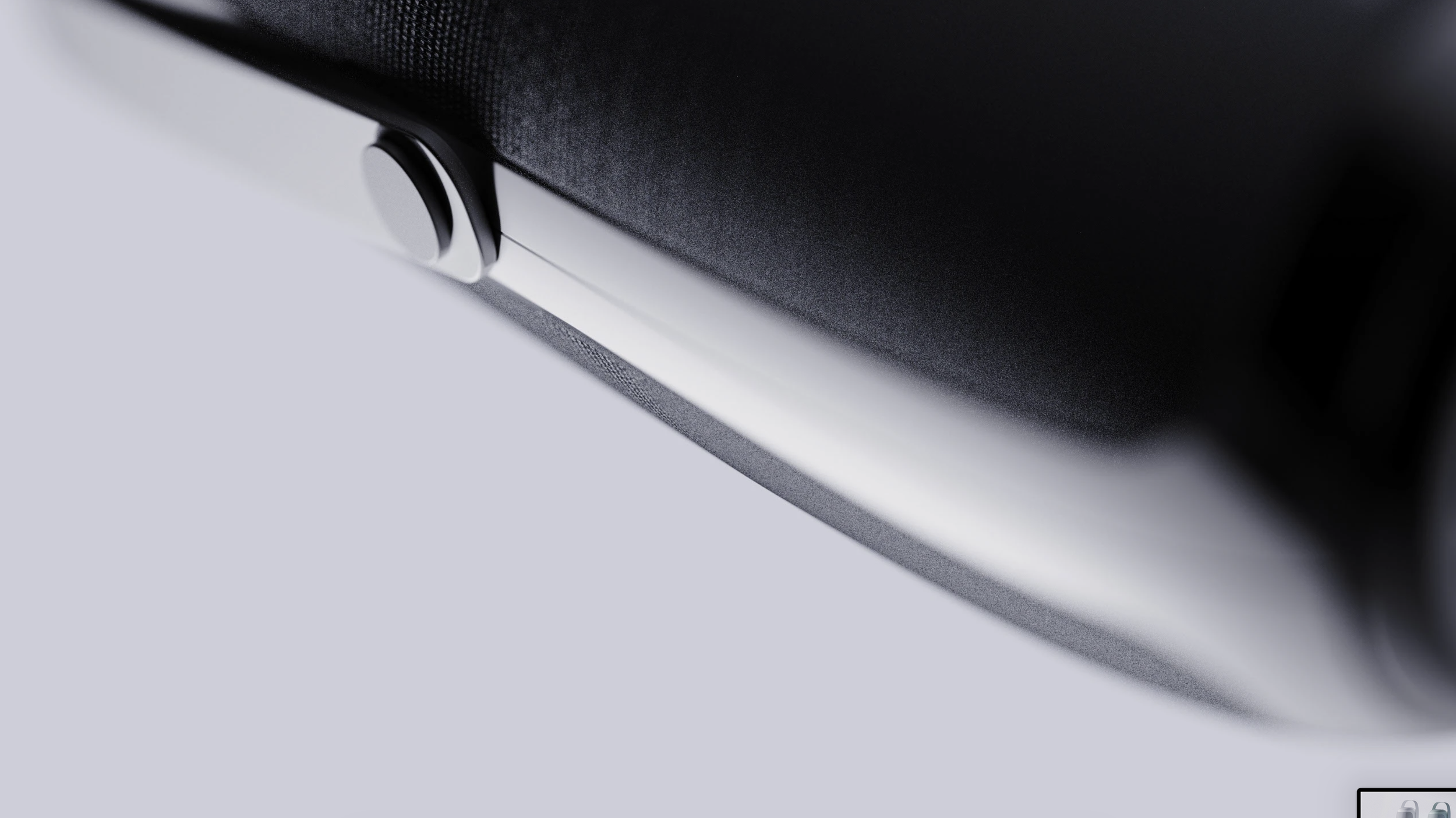 Close-up of a sleek, silver and black electronic device with a textured surface and a circular port or button.