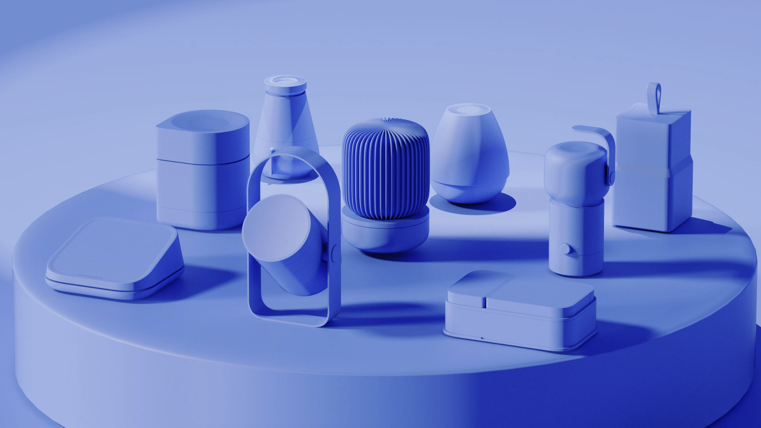 Various modern, minimalistic electronic devices and accessories displayed on a circular table, all in shades of blue.