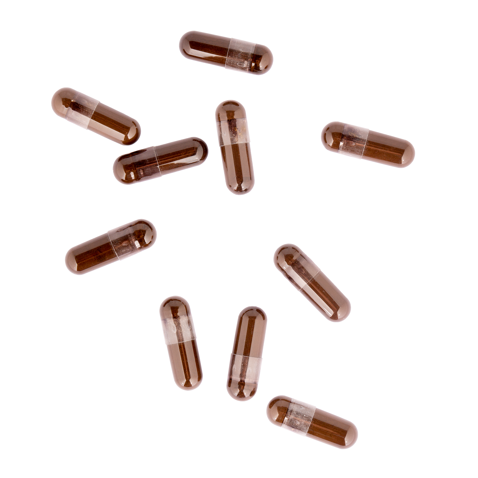 Brown and clear capsules scattered on a white background.