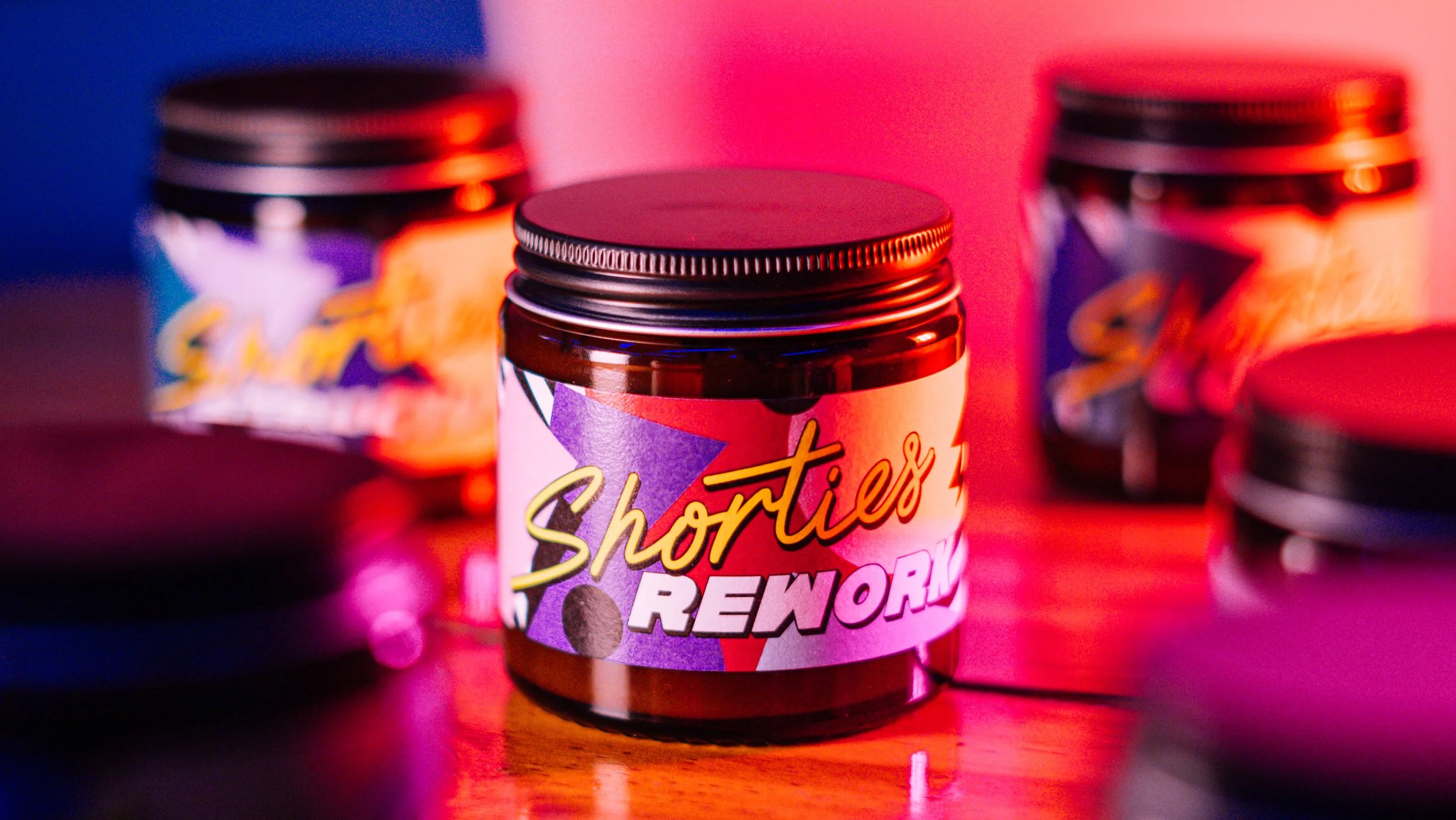 A jar labeled 'Shorties Reworn' surrounded by other similar jars, with colorful lighting in the background.