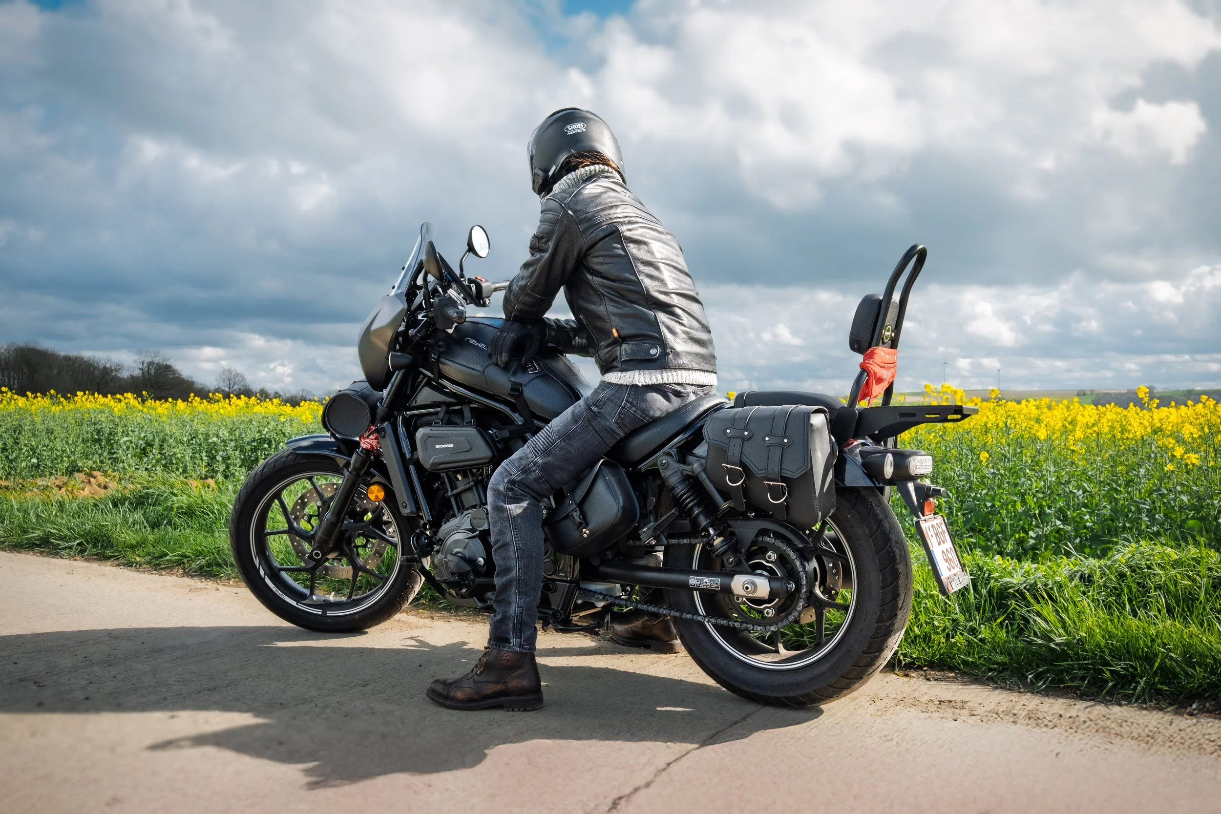 Photographie moto en extérieur, portrait de motard dans un paysage naturel lumineux.