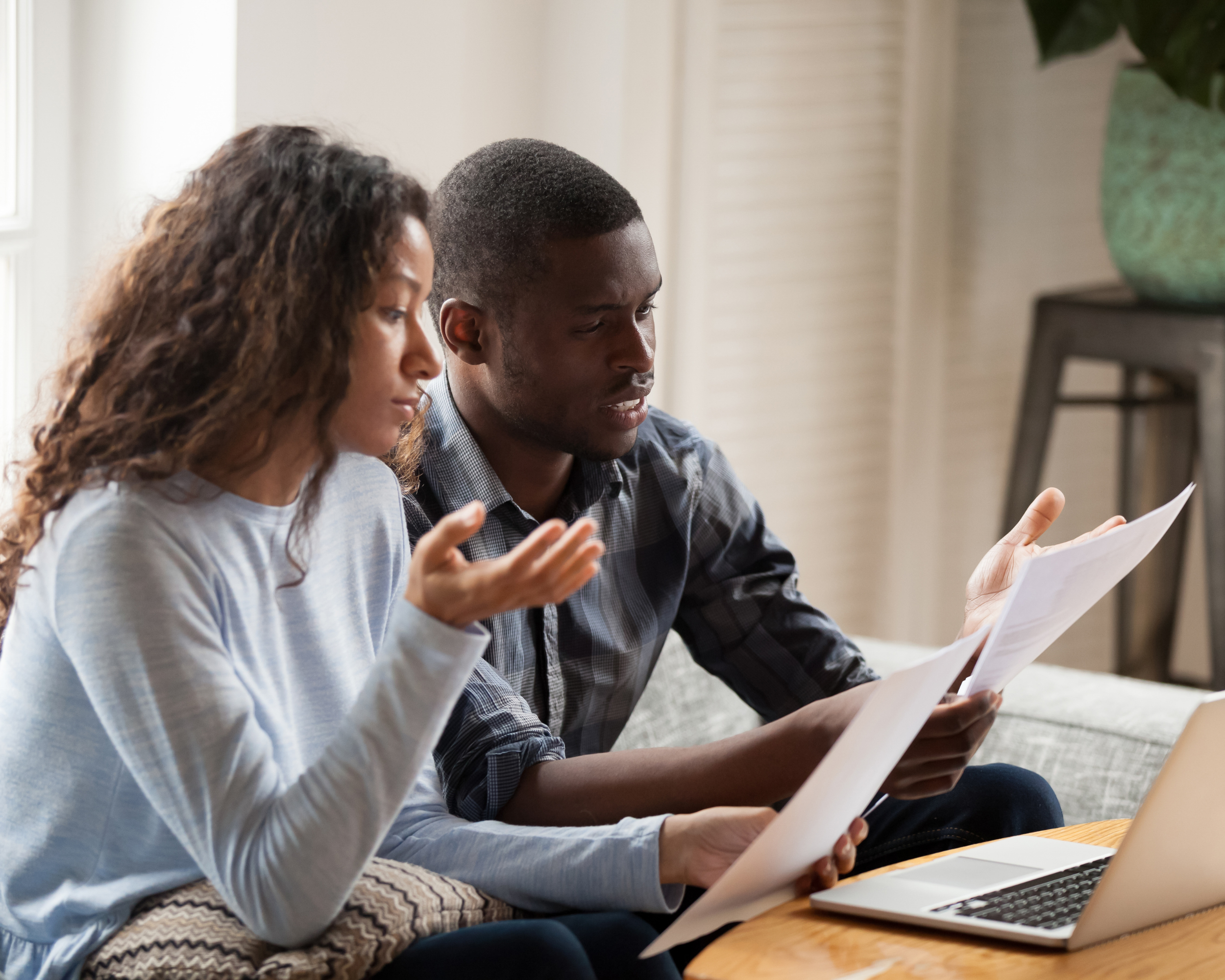 Black couple reviewing OPWDD application documents and Medicaid waiver paperwork at home while navigating developmental disability services in New York State