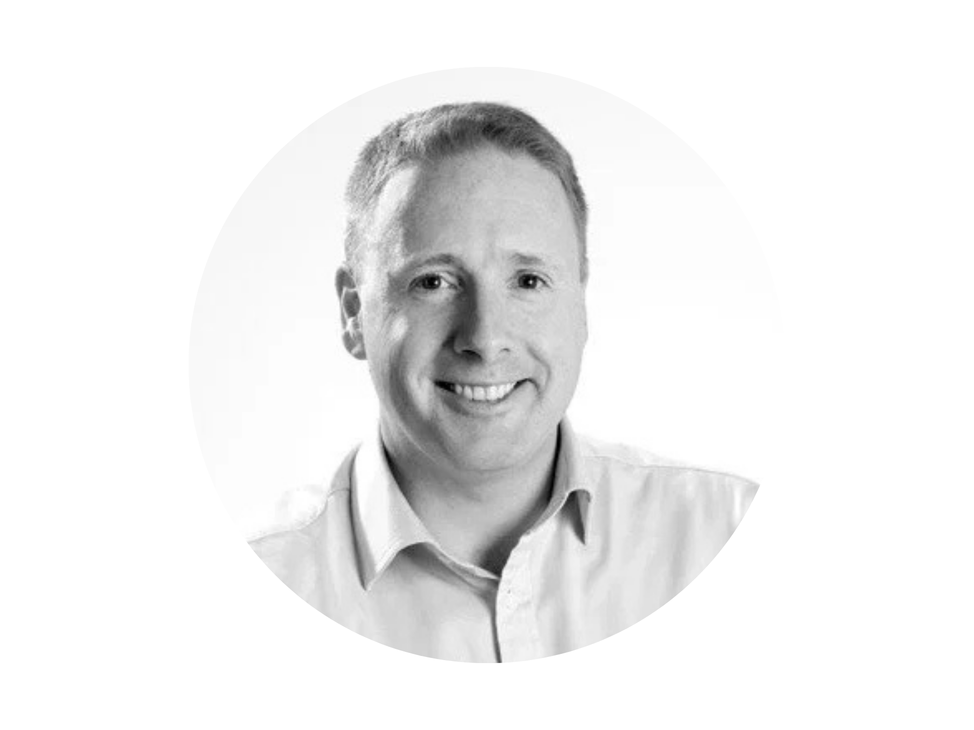 Black and white portrait of a smiling man with short hair, wearing a collared shirt.