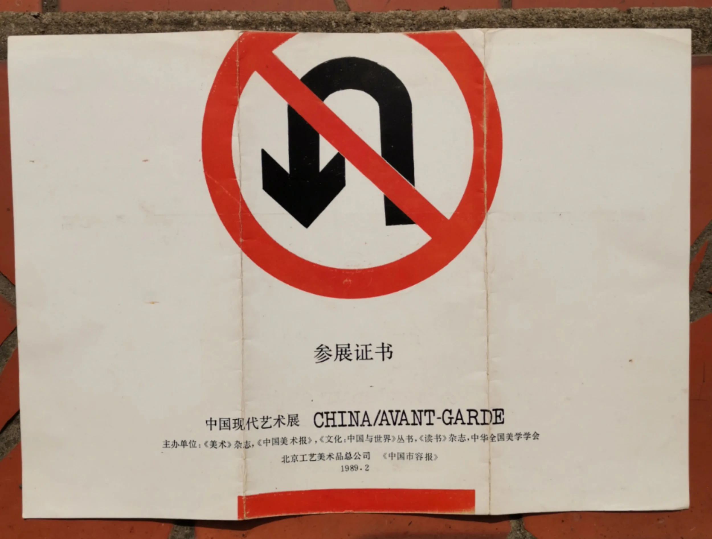 A sign with a black downward arrow crossed out in red circle, indicating no U-turn.