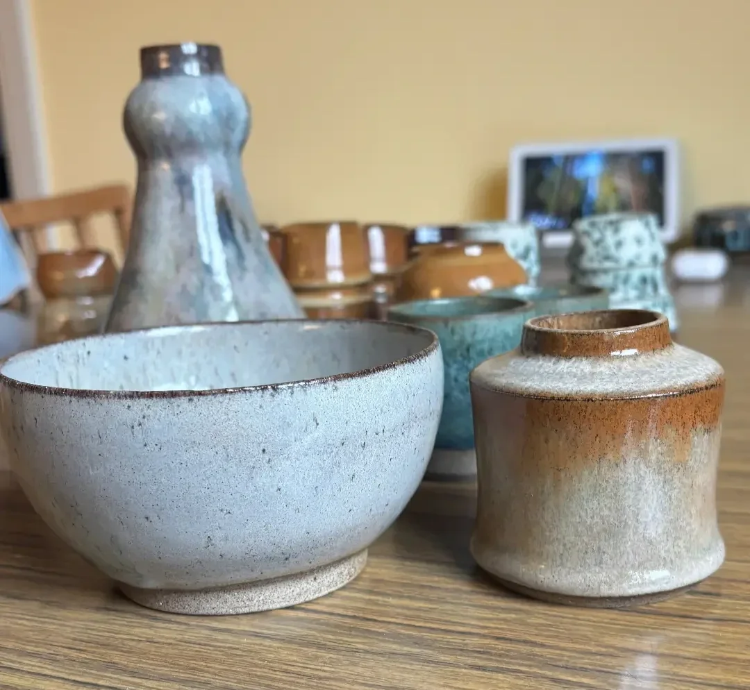 Samling alster som Amanda Reventlid producerat uppställt på ett träbord mot en gul vägg.