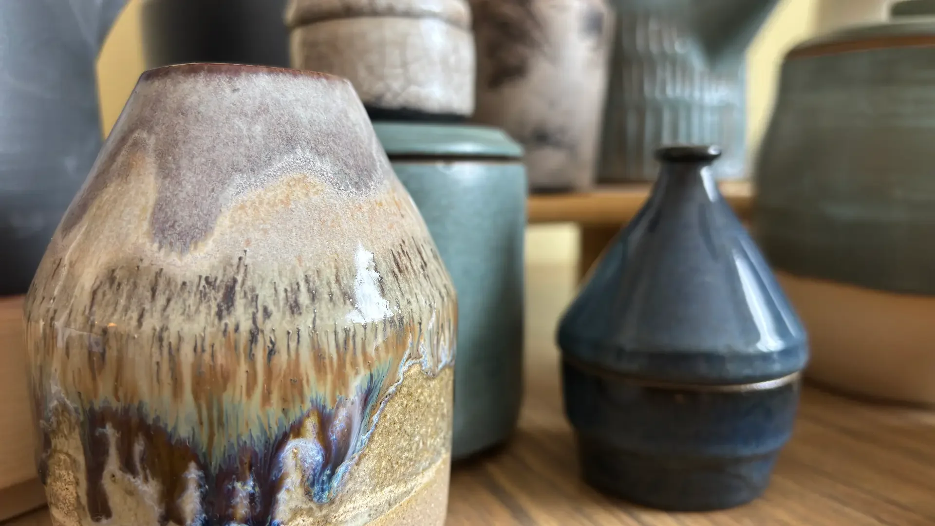 Keramikvasor i olika former och färger på en trävagn