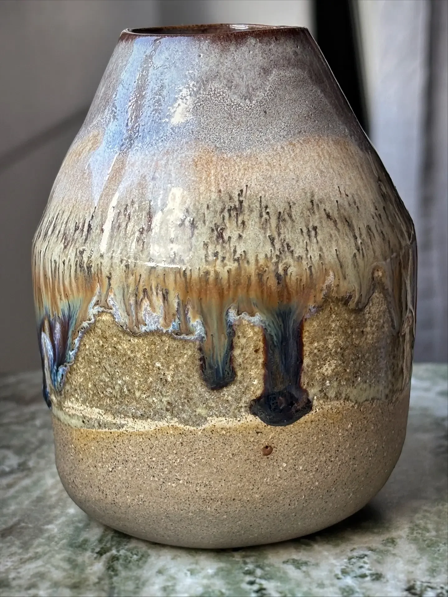 Keramisk vas med intrikat mönster och råbotten placerad på ett träbord.