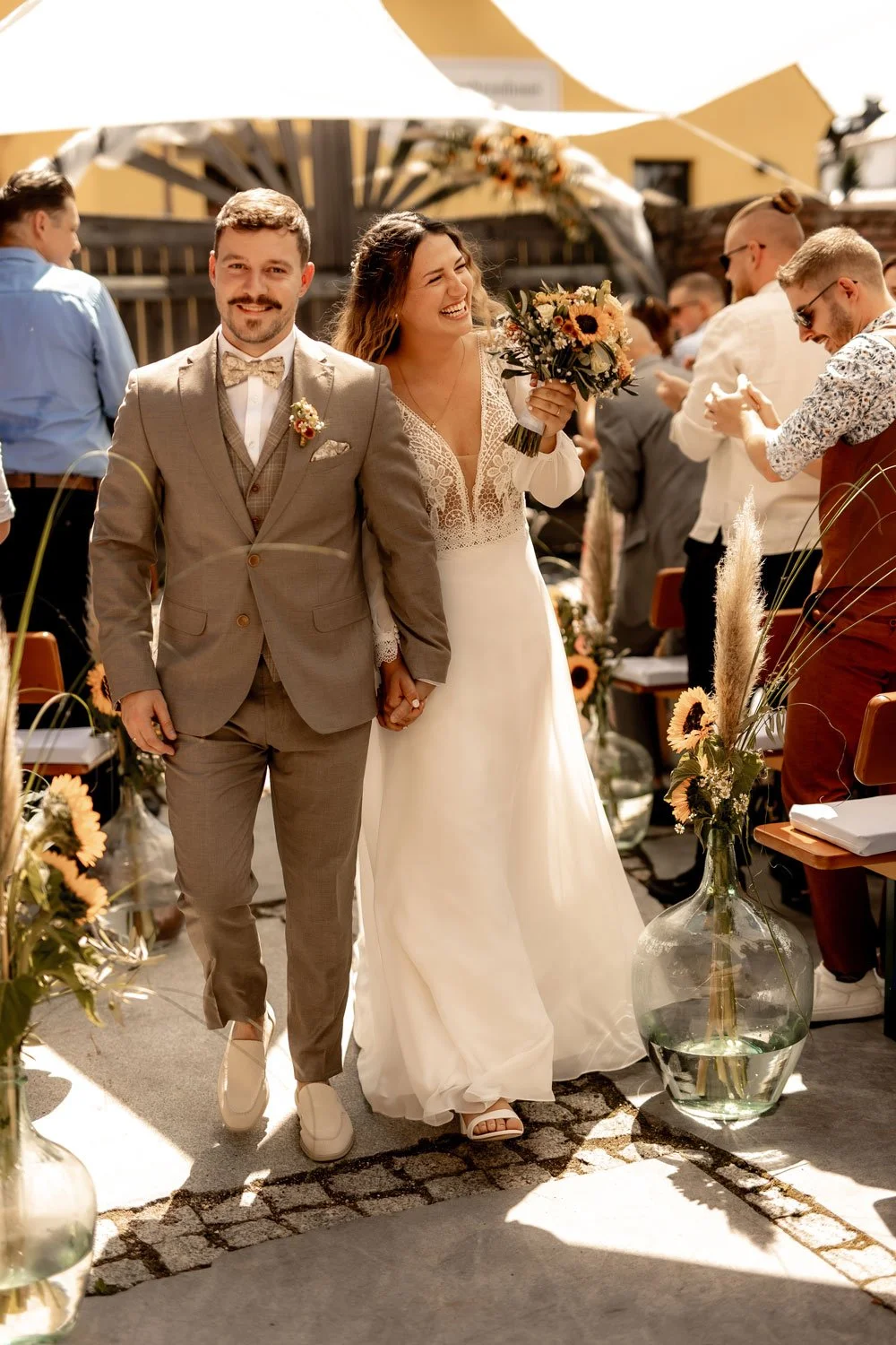 Brautpaar geht fröhlich auf die Kamera zu