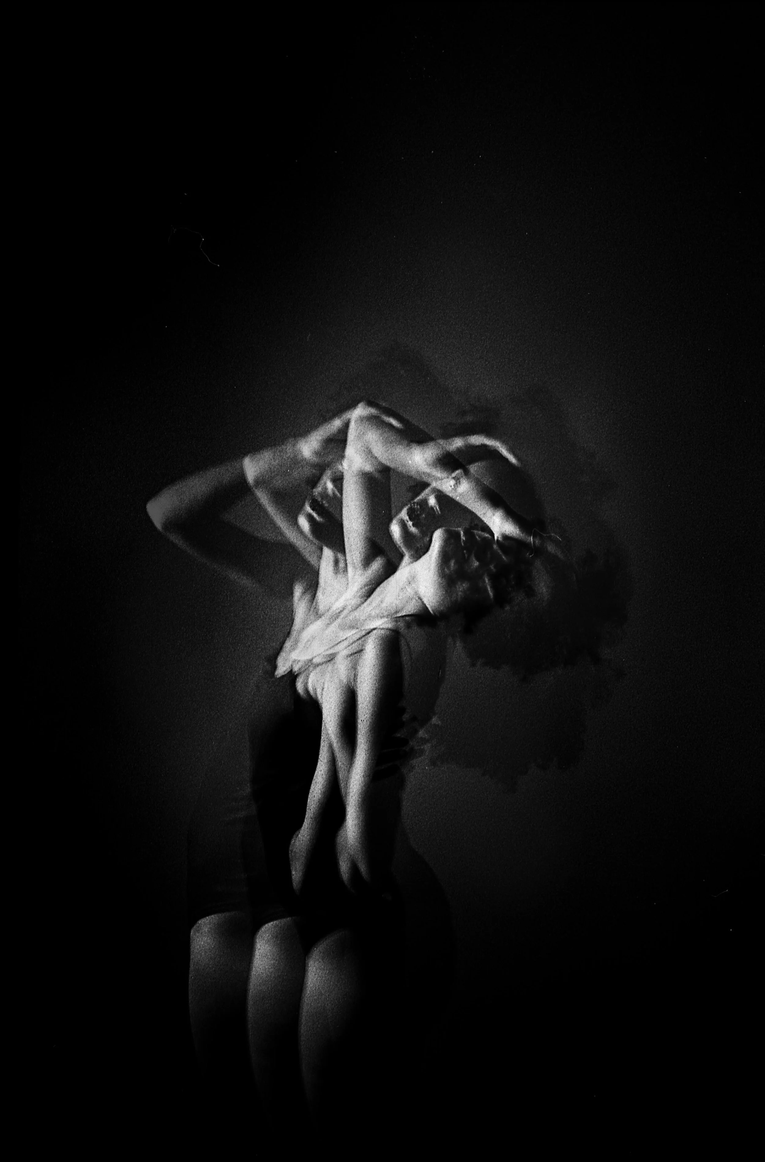 Photo artistique en noir et blanc. Plusieurs juxtapositions de la même personne, debout, un bras relevé, qui bascule vers l'arrière avec le dos courbé.