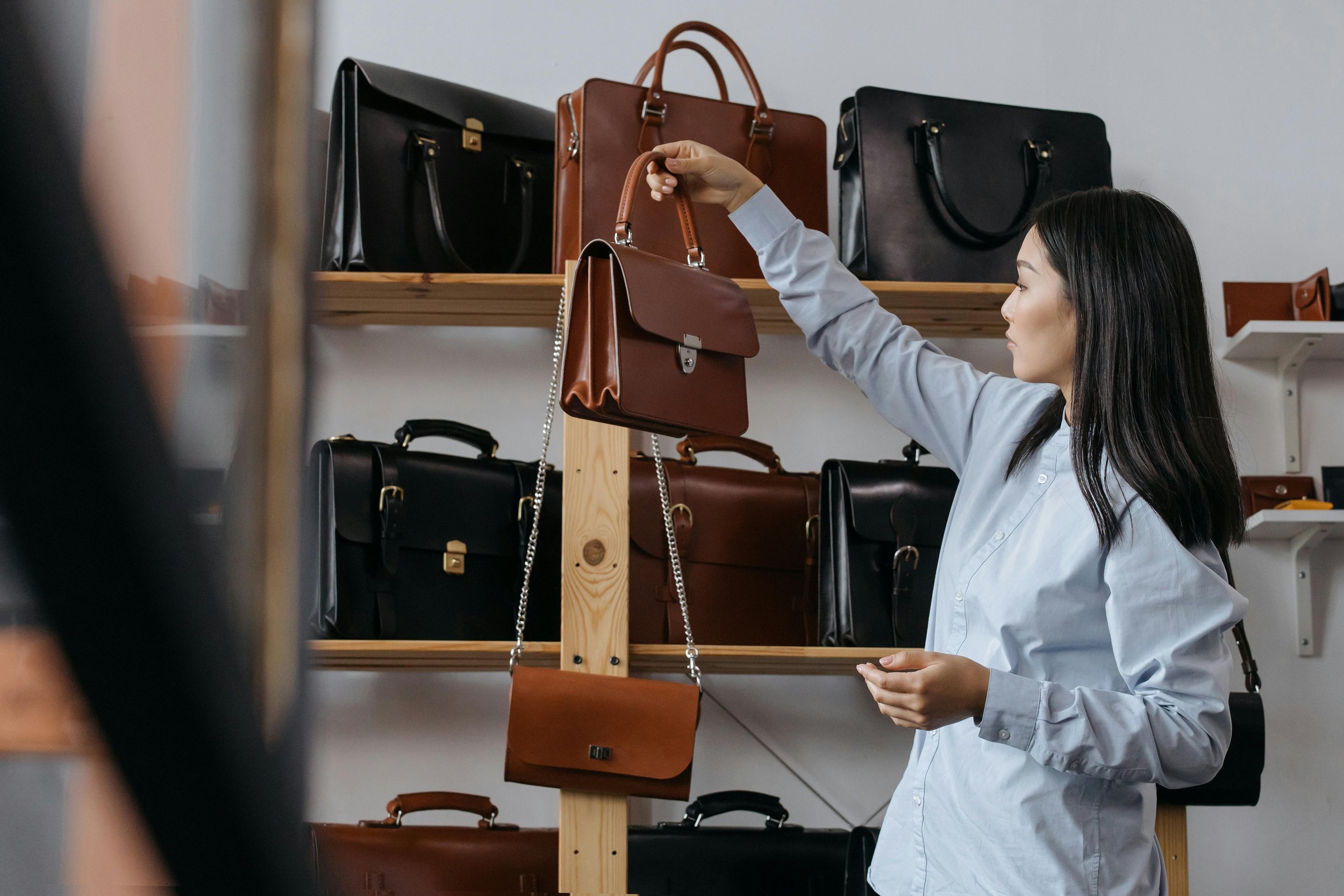 Young woman holding a luxury bag in a shop.