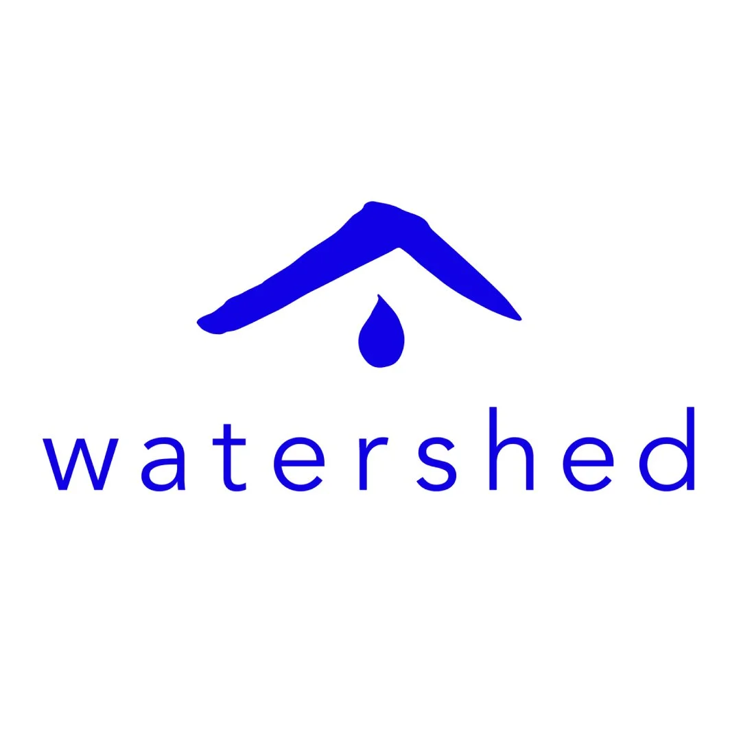 A logo with a blue house-like roof, a water droplet, and the word "watershed" written below in blue lowercase letters.