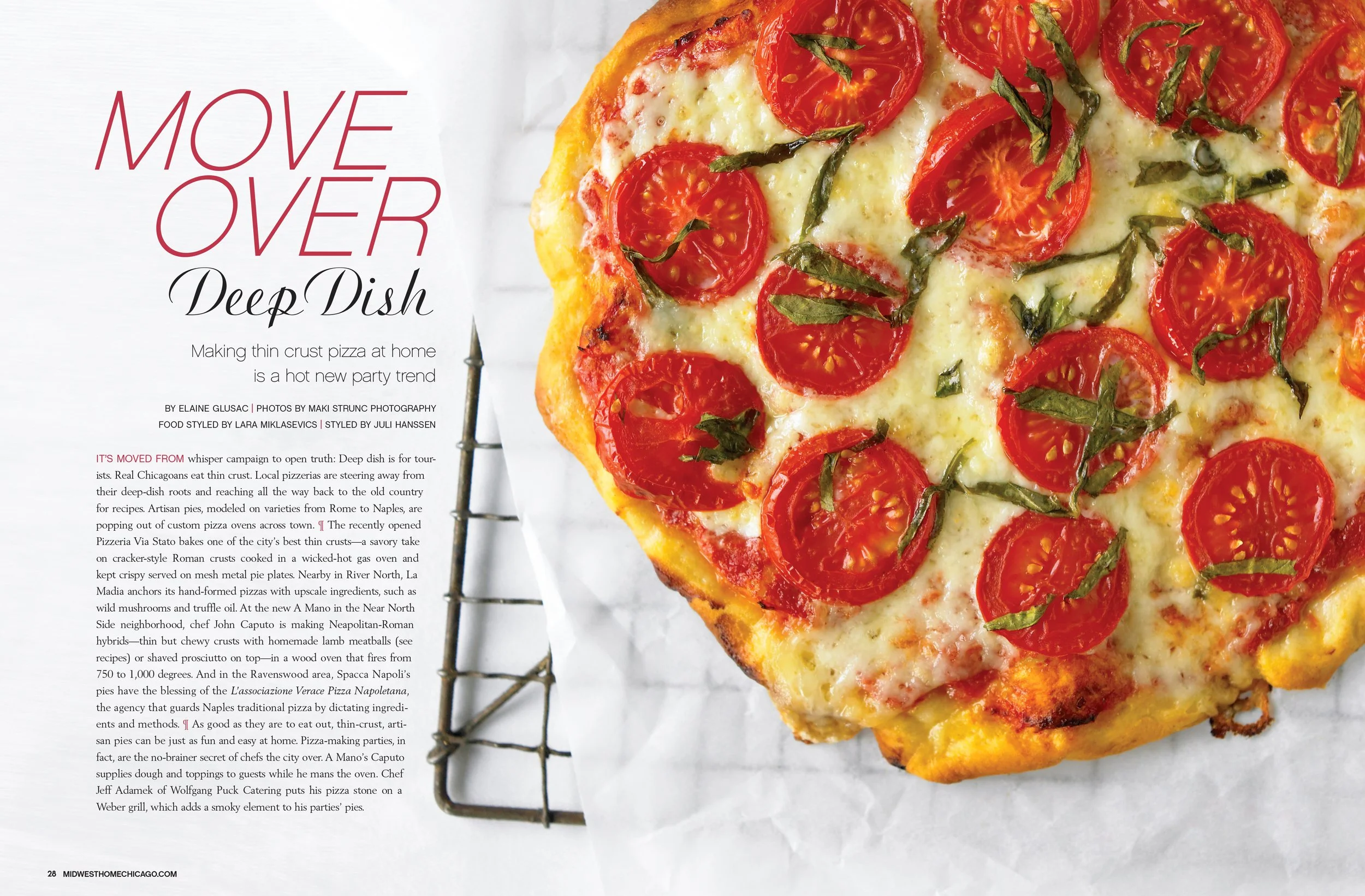 A close-up of a partially cropped pizza topped with cherry tomatoes and fresh basil, on a wire rack with a piece of white parchment paper.